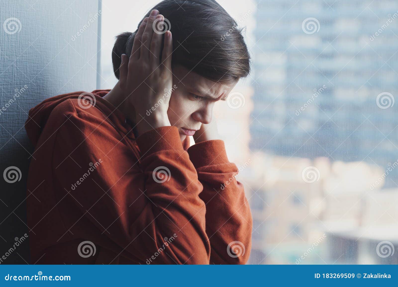 young sad depressed frustrated autistic woman sitting at home alone suffering from head ache and psychological problems