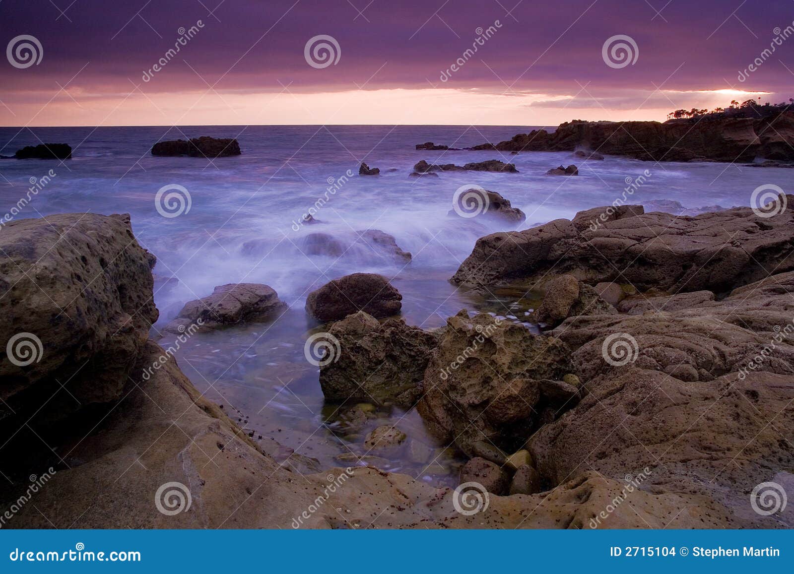 Mer épique. Ondes roulant dans le littoral rocheux au coucher du soleil