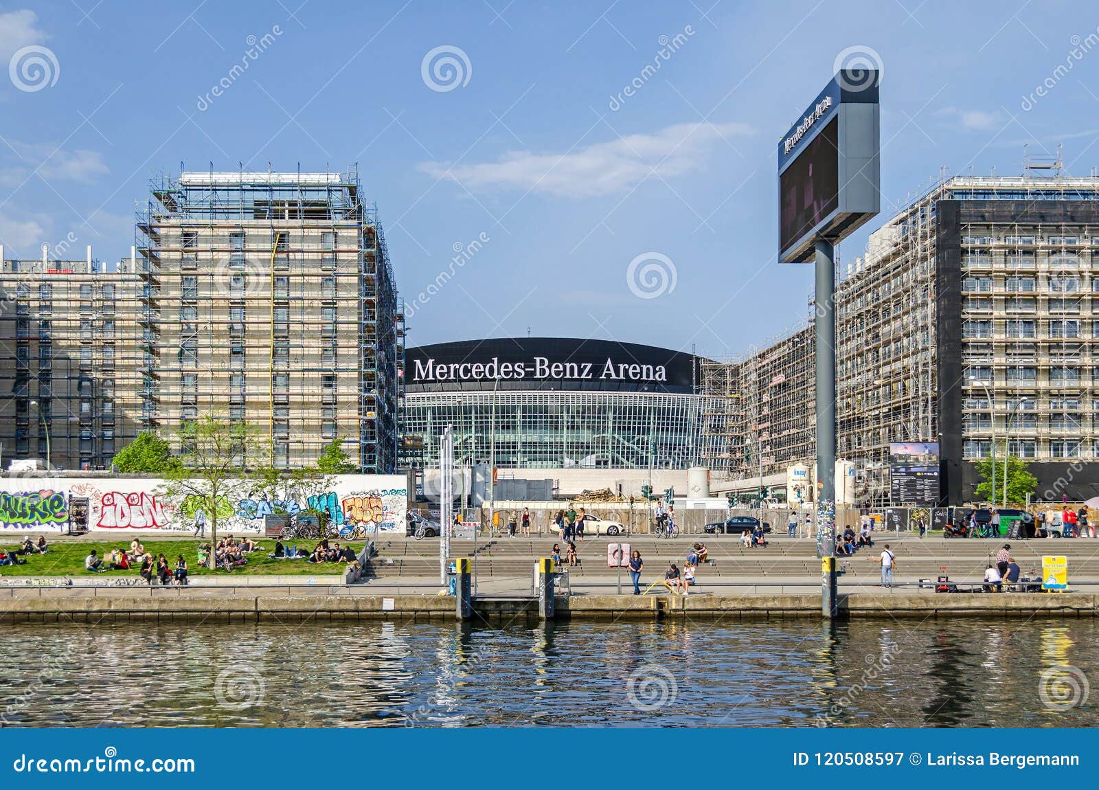 Mercedes-Benz arena od rzecznego bomblowania w Berlin, Germany. Berlin Niemcy, Kwiecień, - 22, 2018: Mercedes-Benz arena, wielocelowa salowa arena, jak widzieć od rzecznego bomblowania z swój bankiem i deptak cieszy się ciepłego wiosna dzień ludzie i