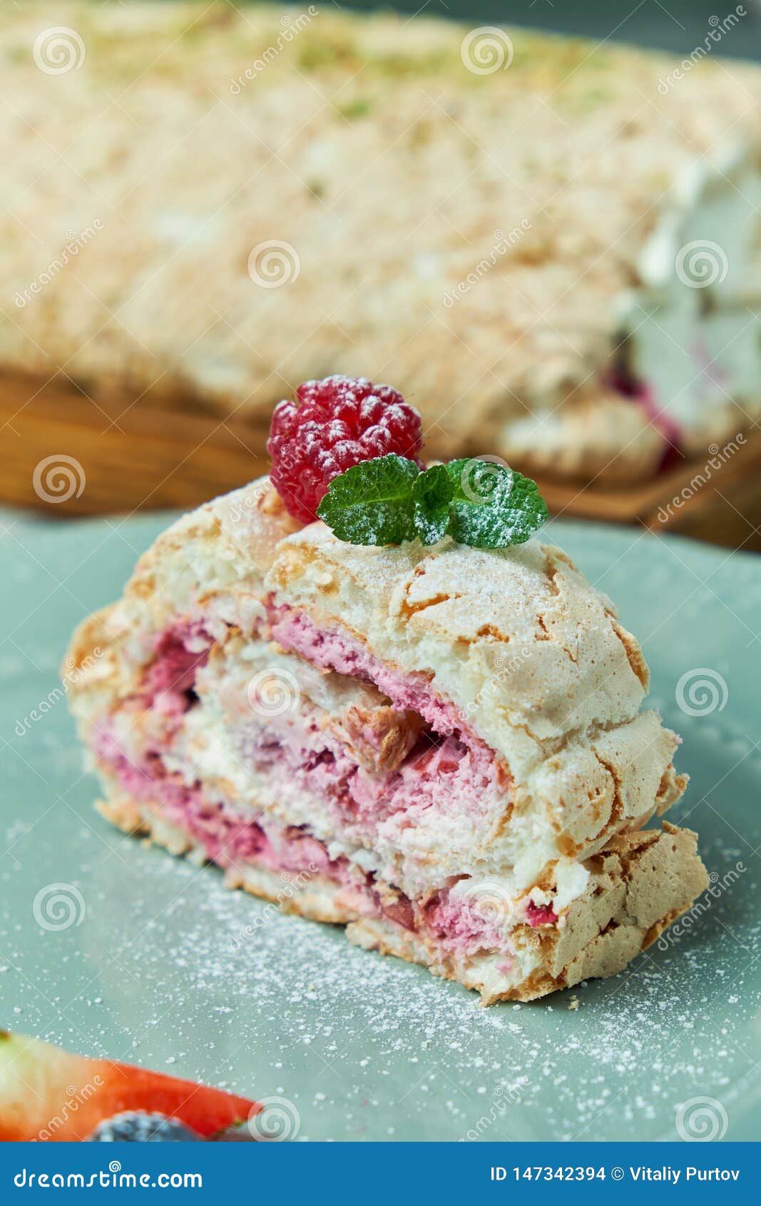 Meringue Cake Roll Slice on a Plate with Berries, on a Gray Background