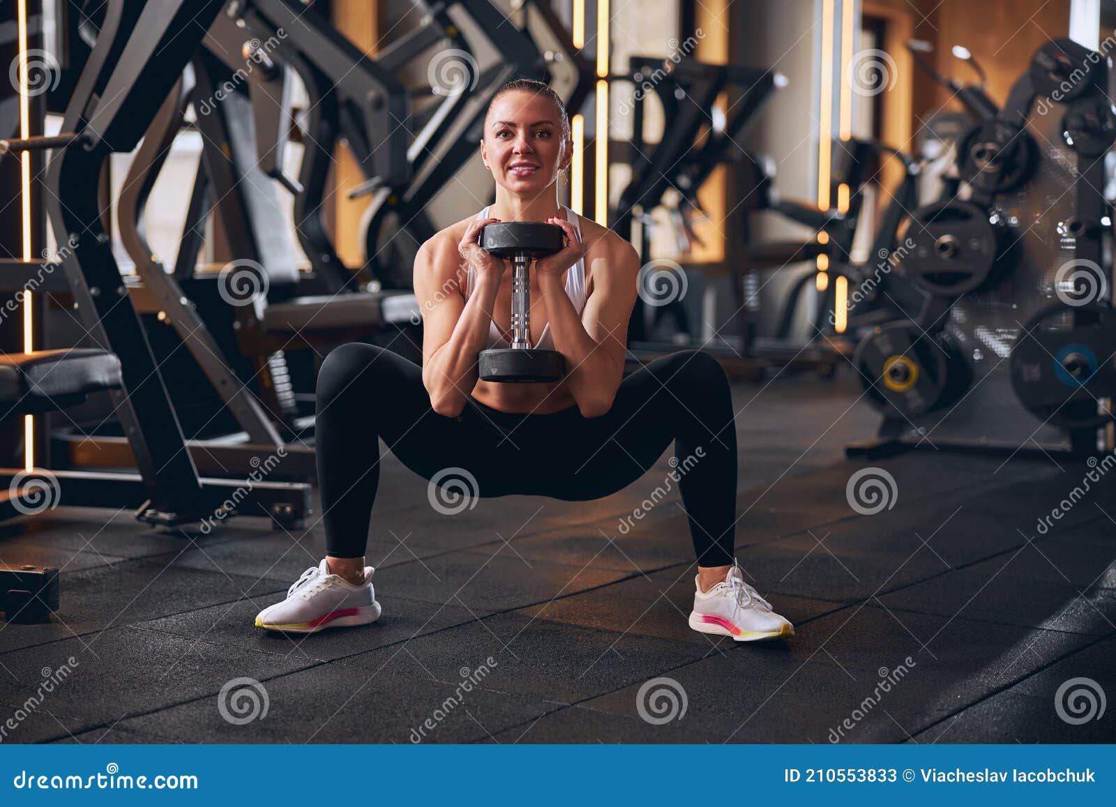 cheerful young woman exercising buttocks in gym