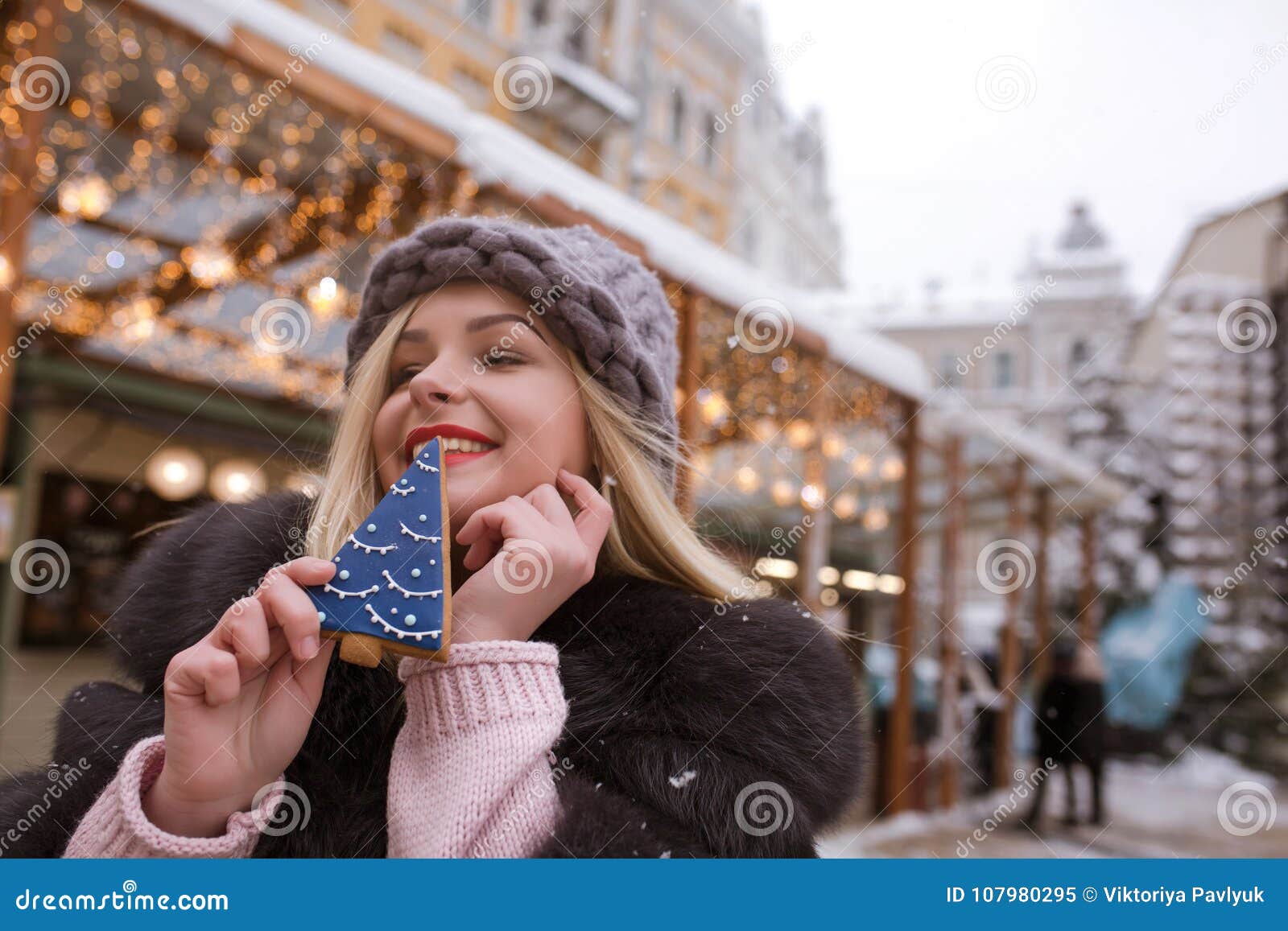 Merry Blonde Woman Holding Savory Gingerbread Against Light Decoration ...