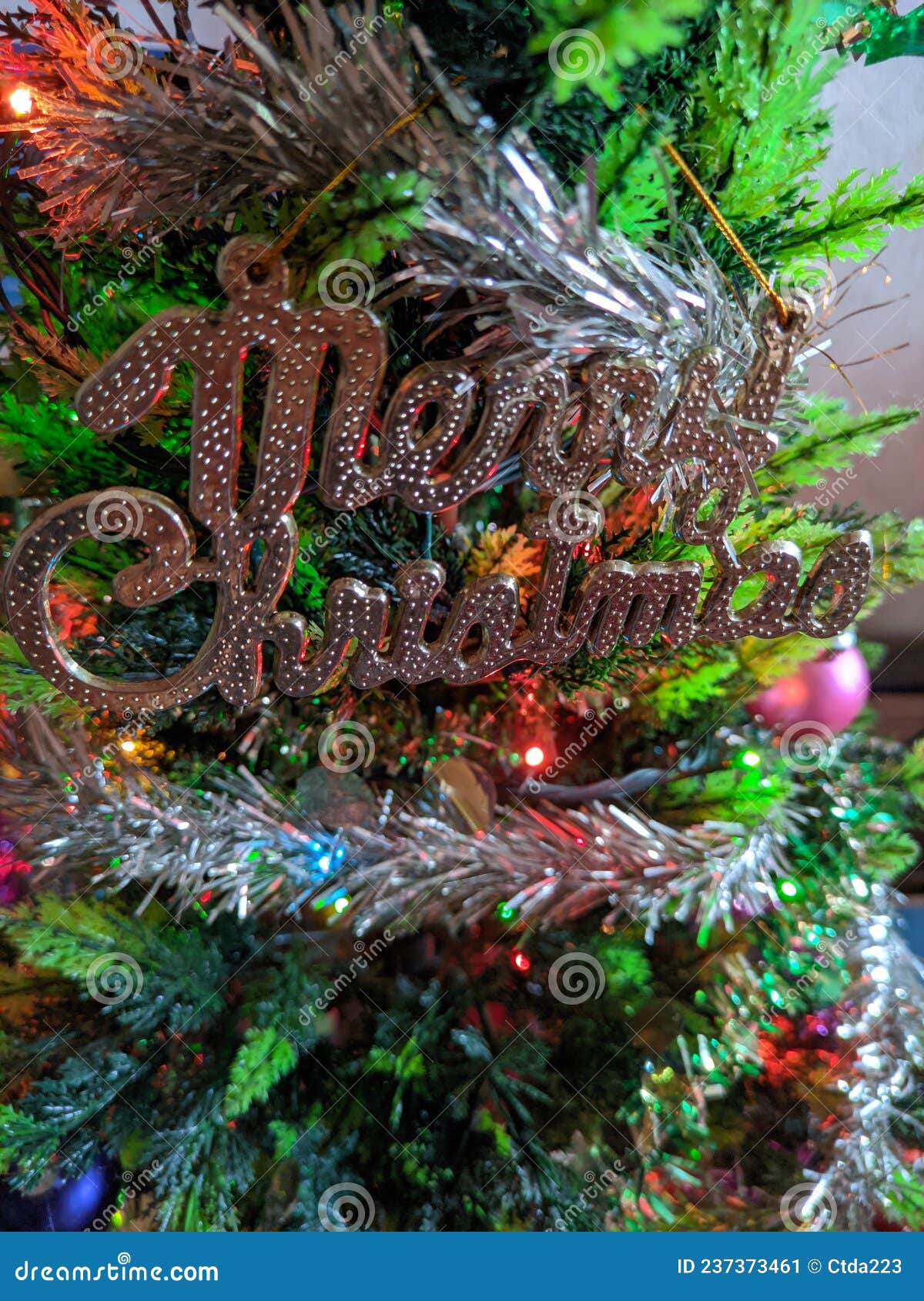 Merry Christmas Ornament with Silver Tinsel on the Christmas Tree Stock