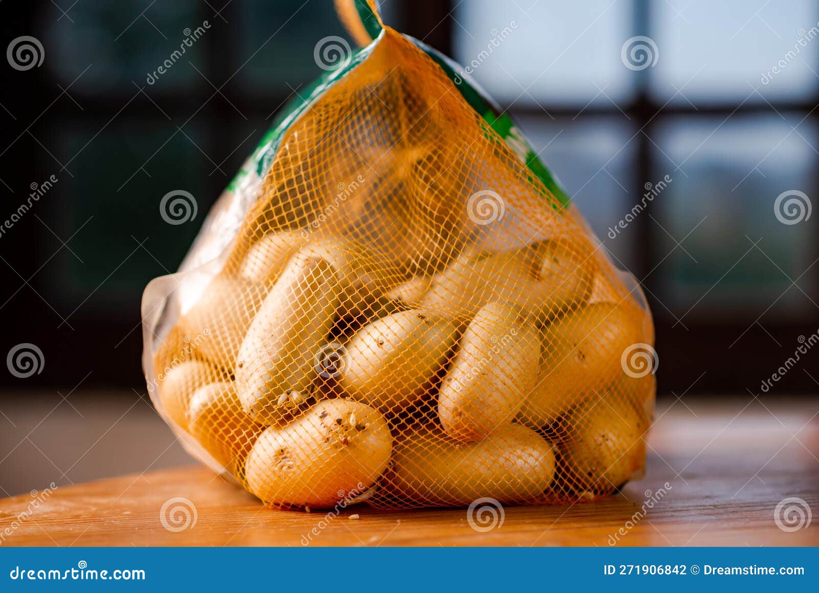 Mesh Bag with Whole Potatoes. Sale or Purchase of Potatoes Stock Photo