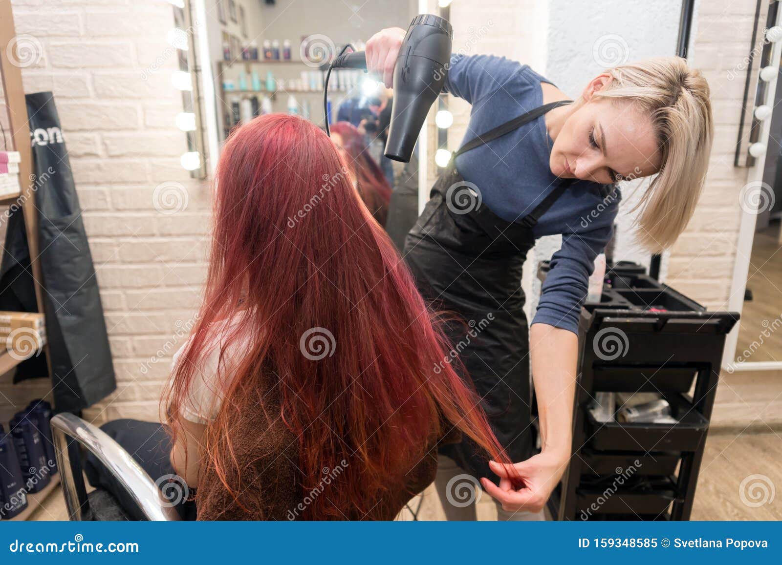 Mestre cabeleireiro faz penteado feminino com secador de cabelo e produtos  para o cabelo