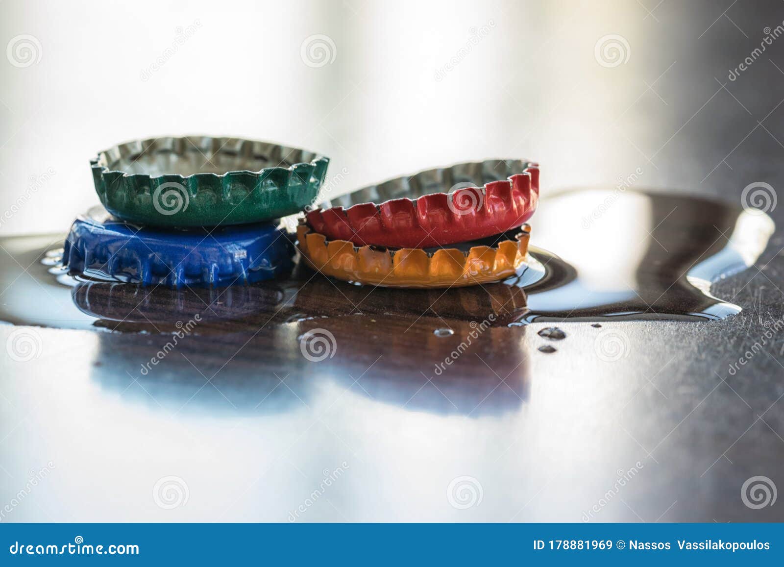 Colorful Metal Caps on Wet Reflective Smooth Clean Surface Stock Image
