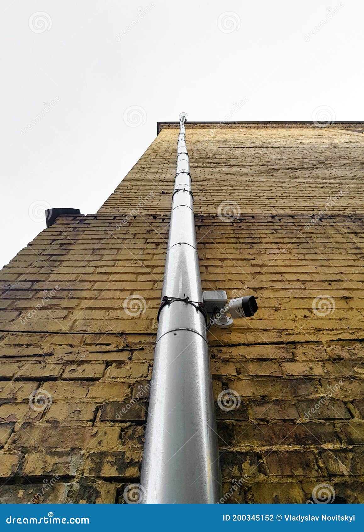 Metal Downspout Against the Background of a Yellow Brick Building Stock