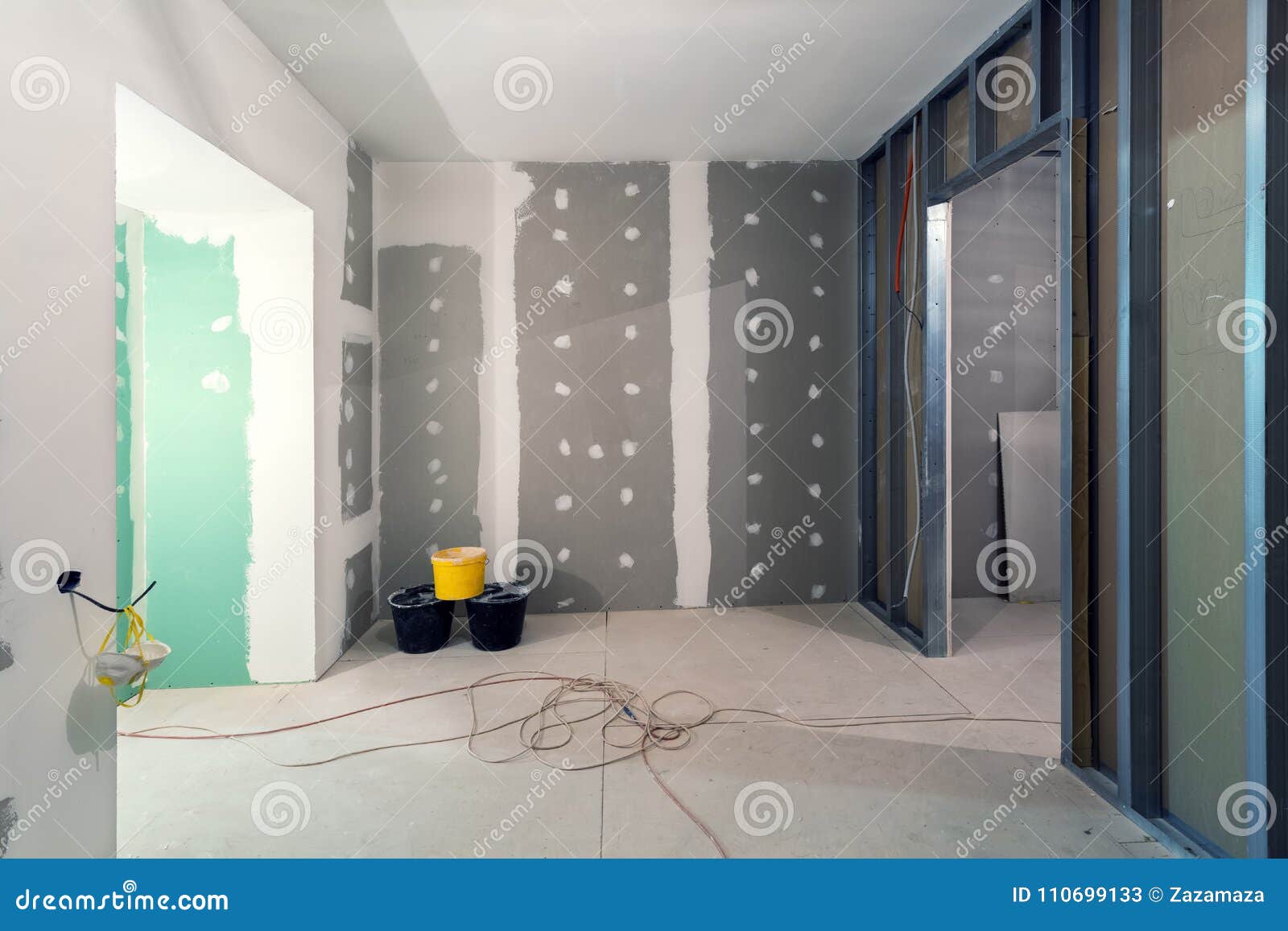 metal frames and plasterboard drywall for gypsum walls, three buckets and electric wires in apartment is under construction
