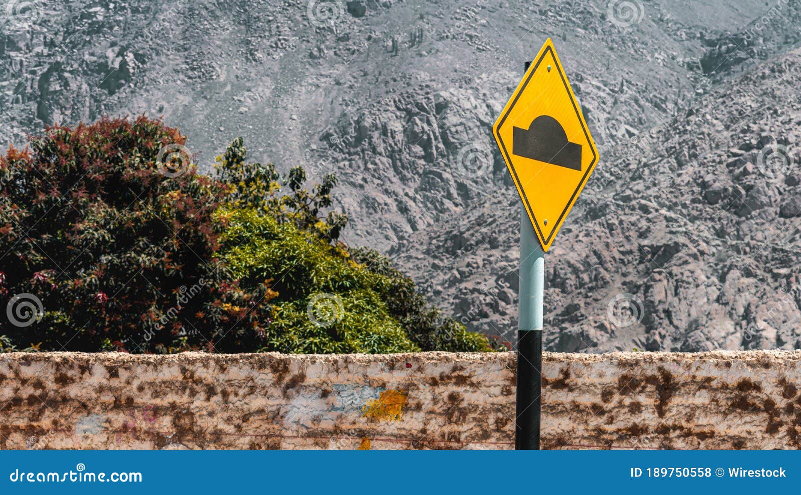 Metal, Yellow Road Bump Sign on the Side of the Road Stock Photo