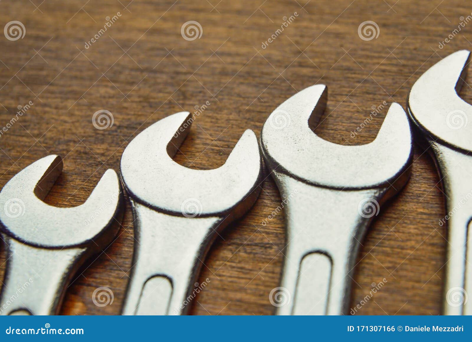 metallic wrenches on a wooden background