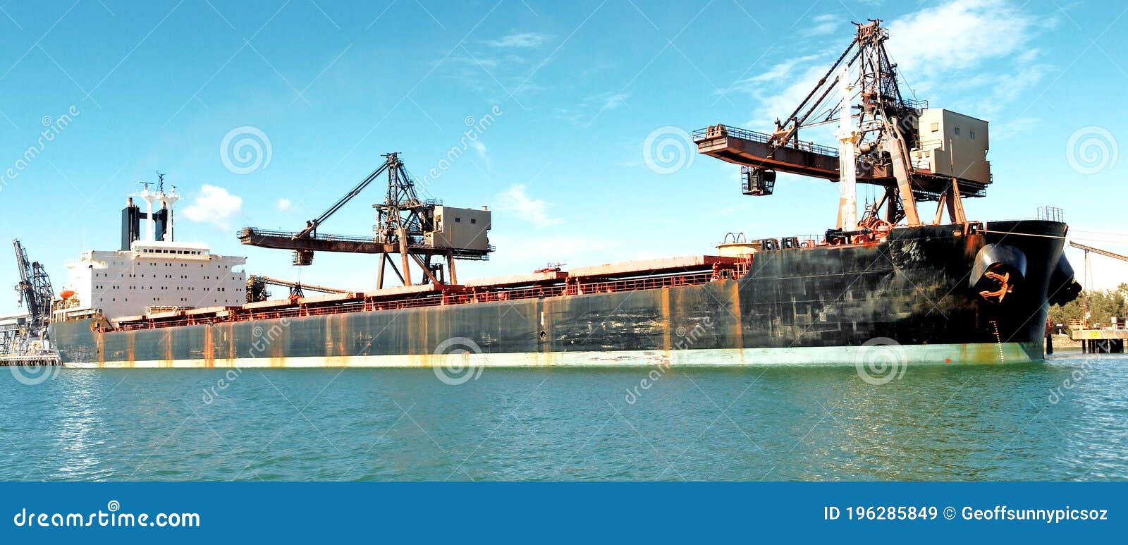 A 154 meter Bulk Carrier Ship loading at a Gladstone Harbour terminal. Queensland, Australia. A 154 meter Bulk Carrier Ship loading at a Gladstone Harbour terminal. Full length Starboard side view. Queensland, Australia