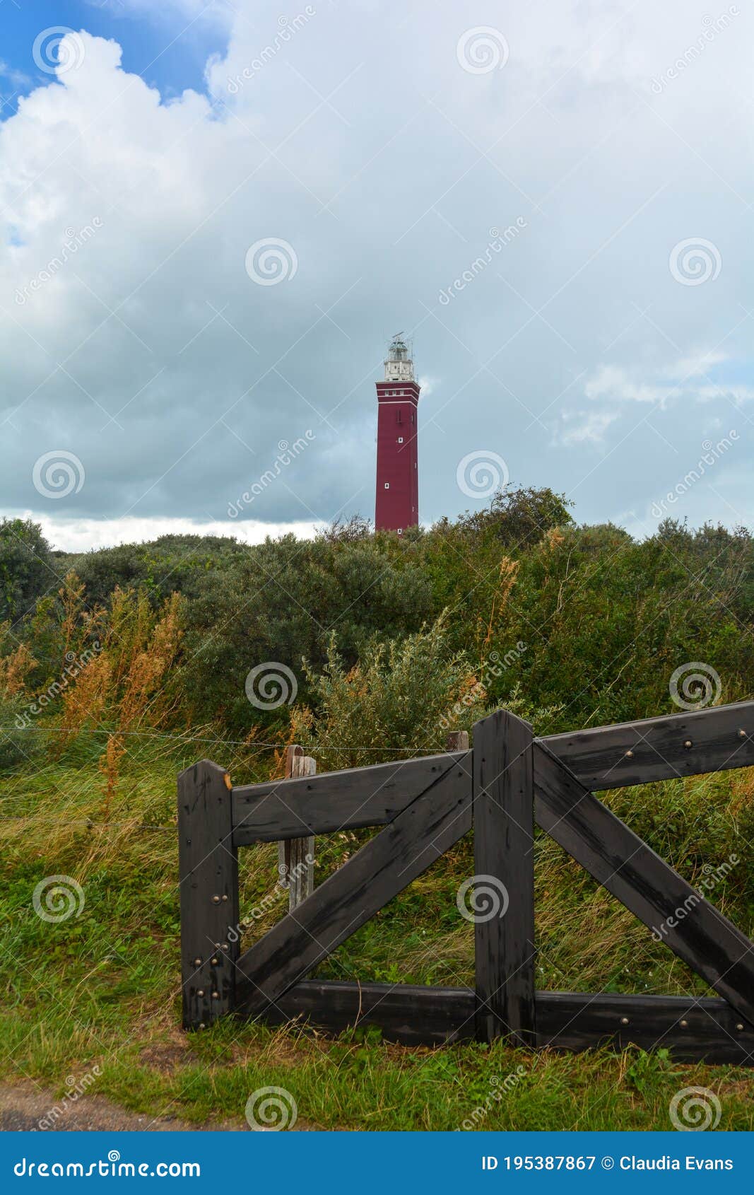 westhoofd lighthouse in ouddorp in the netherlands, in a landscape and a fence