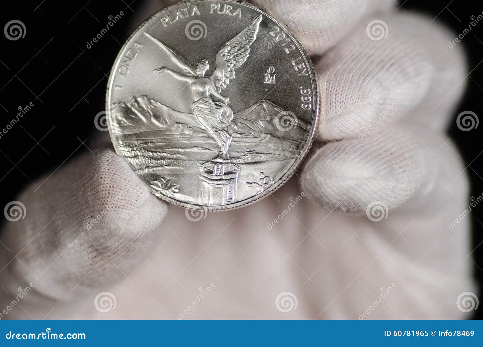 mexican libertad silver coin hand held