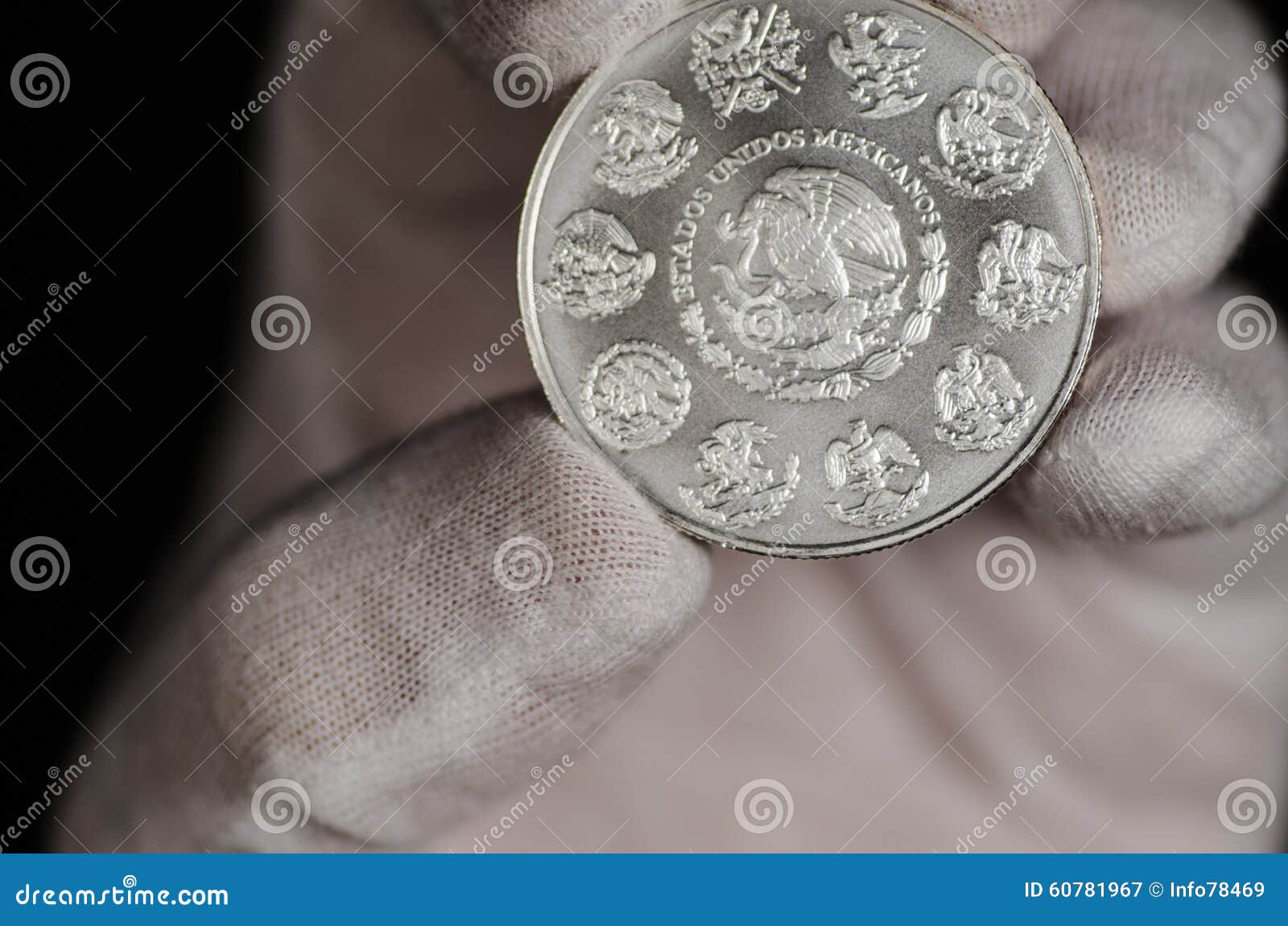 mexican libertad silver coin hand held