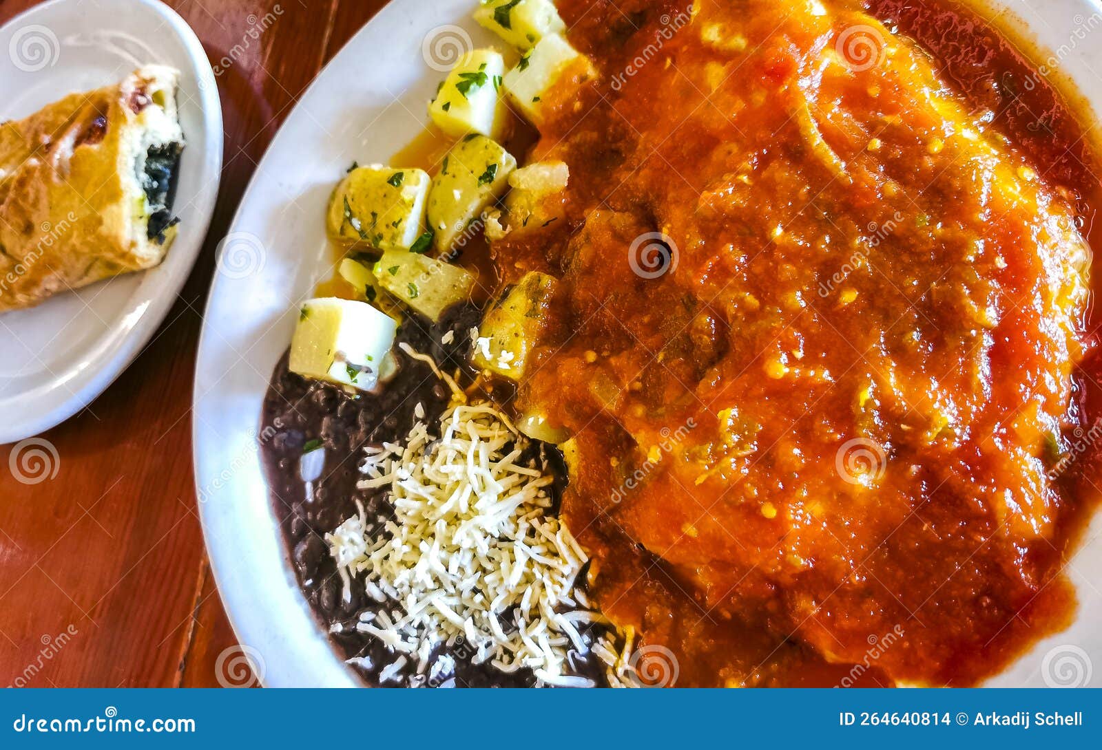 mexican omelet with black beans potatoes nachos on white plate