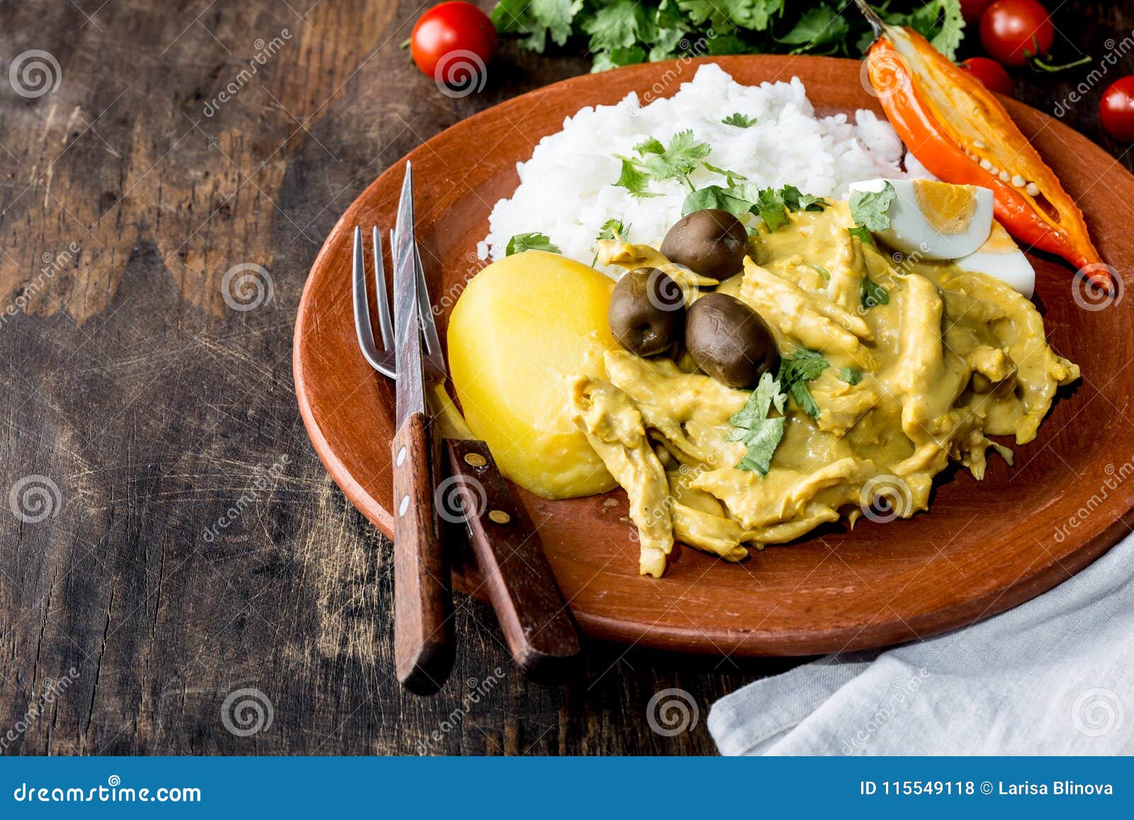 mexican and peruvian cuisine. aji de gallina. chicken aji de gallina with olives egg and rice on clay plate. tipical