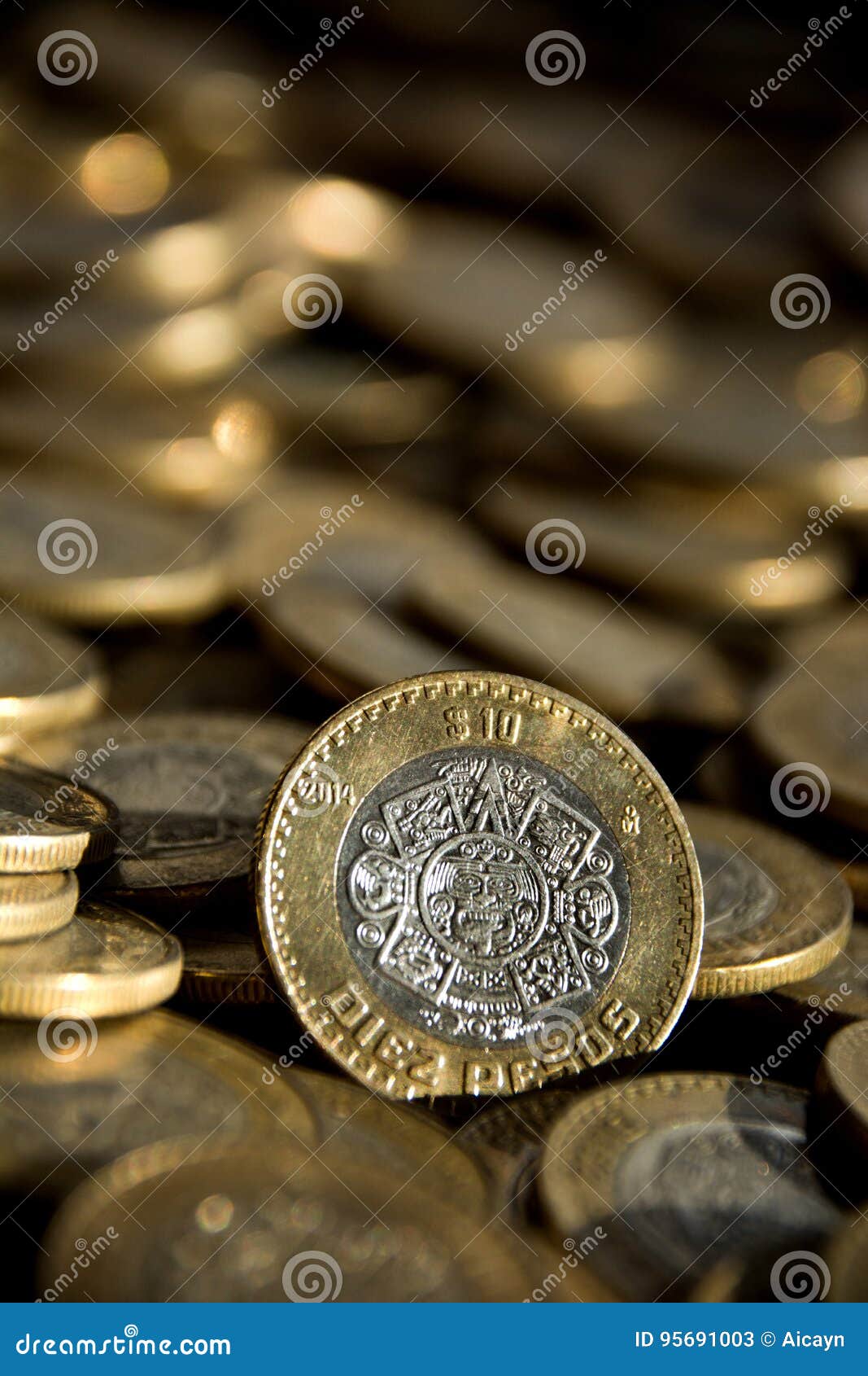 mexican 10 pesos coin in the foreground, with many more coins in the background