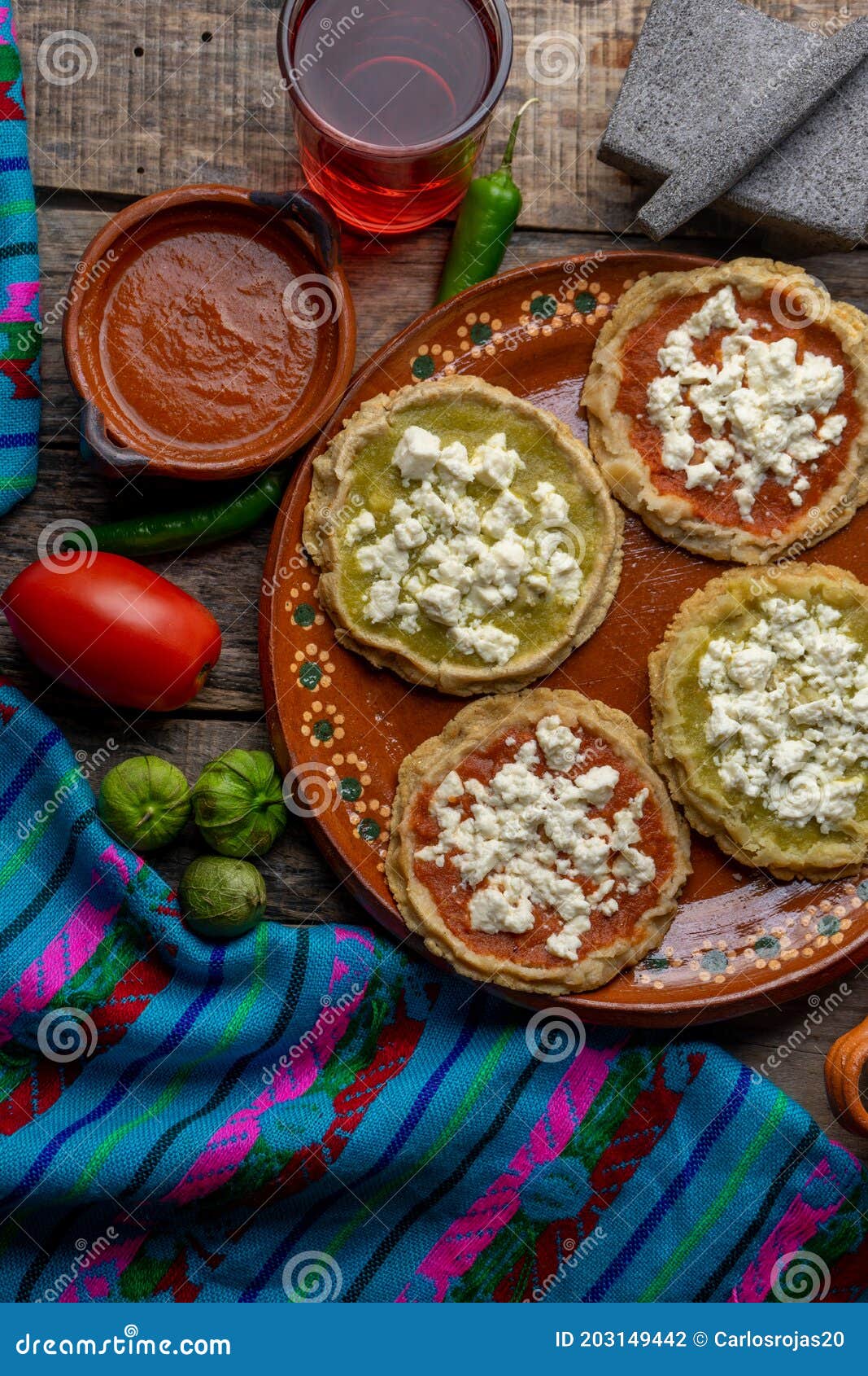 mexican picaditas with sauce and fresh cheese on wooden background