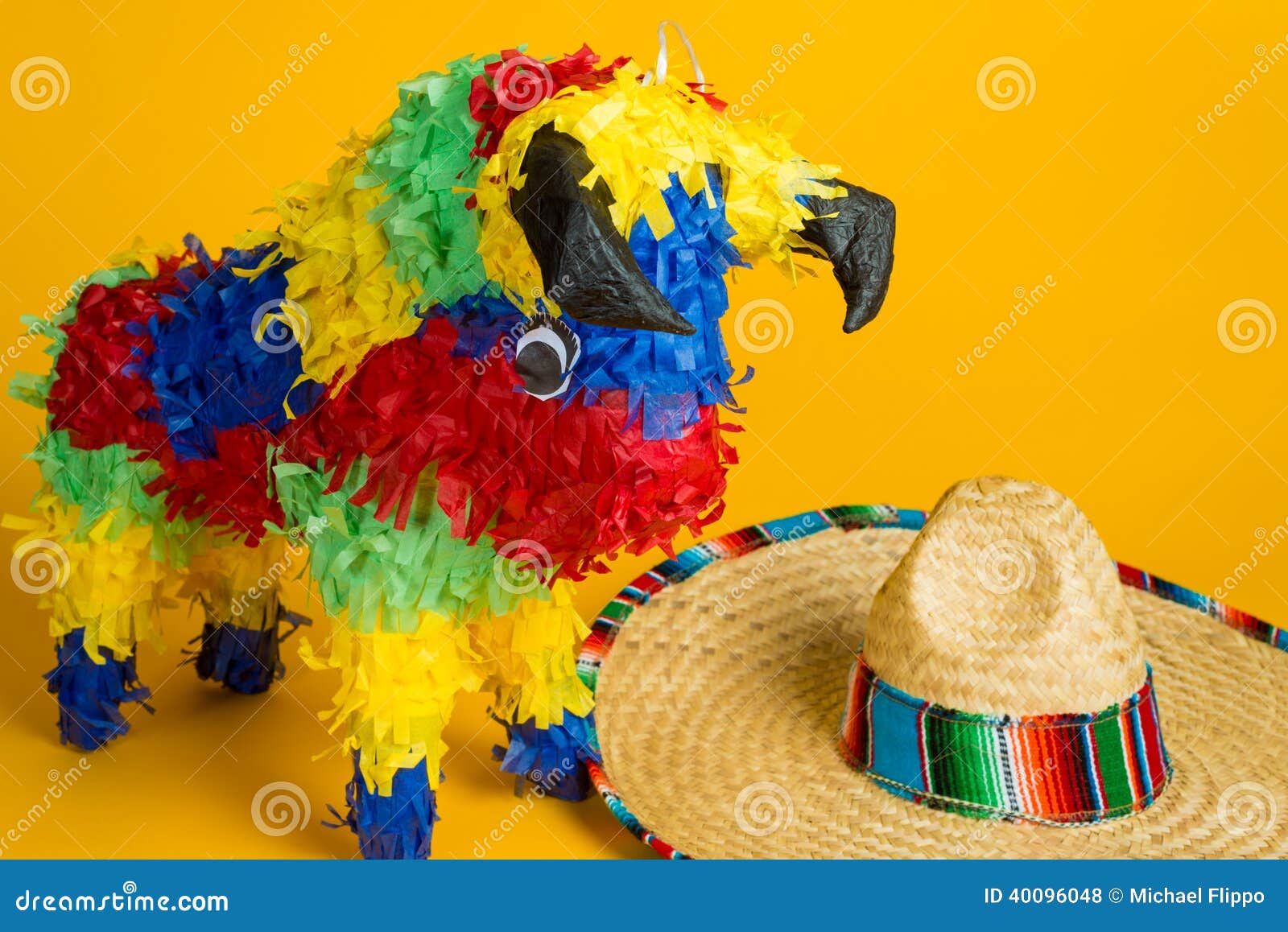 mexican pinata and sombrero on yellow