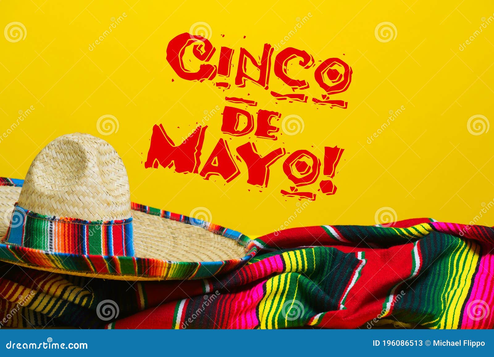 mexican serape blanket and sombrero on yellow background with cinco de mayo.