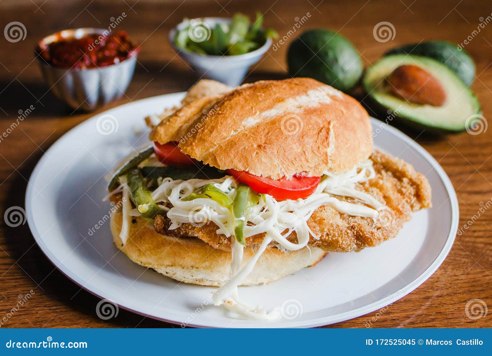 mexican torta is chicken milanese sandwich with avocado, chili chipotle and oaxaca cheese