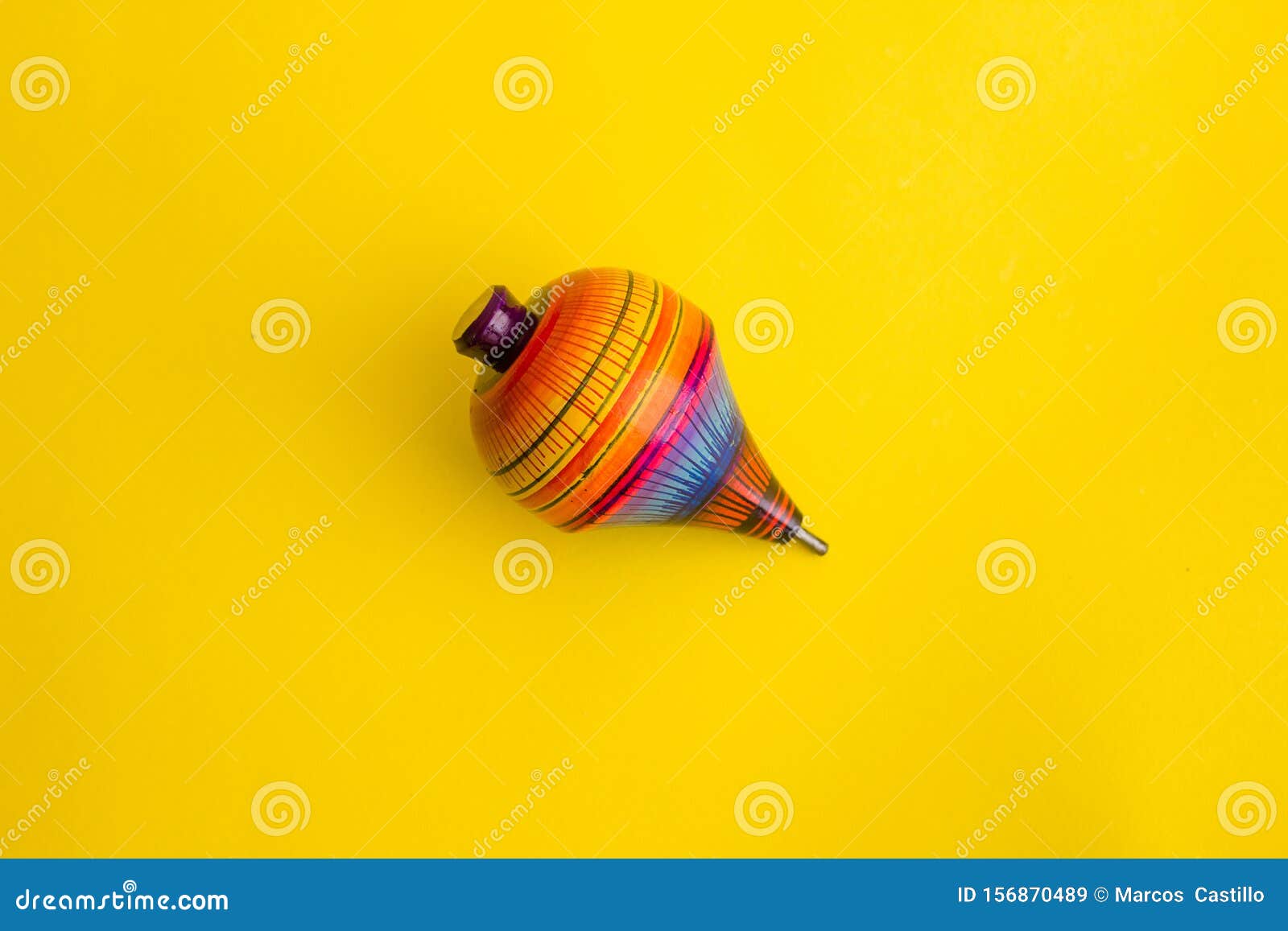 mexican toys, trompo from wooden in mexico on yellow background