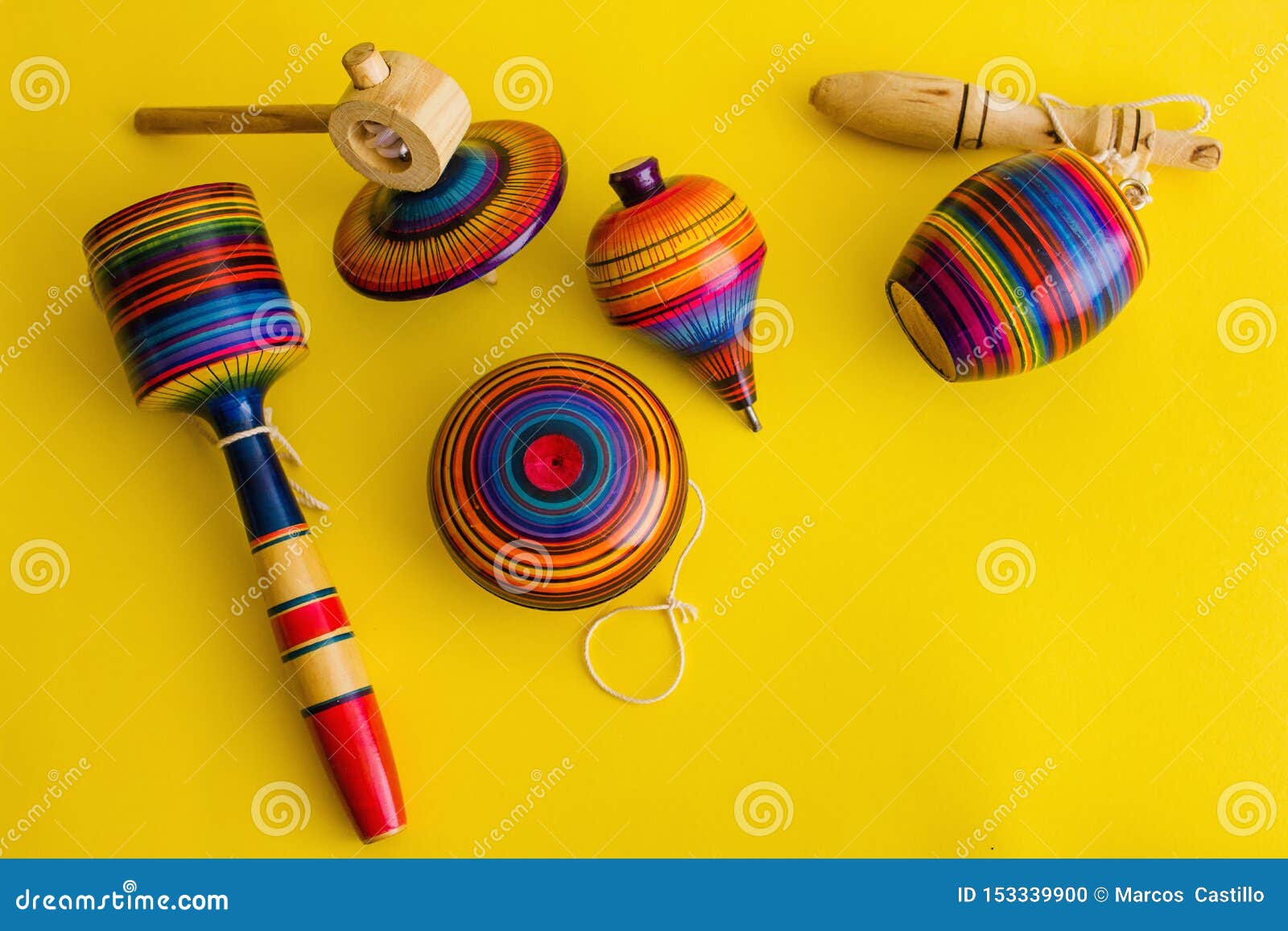 mexican toys from wooden, balero, yoyo and trompo in mexico on a yellow background