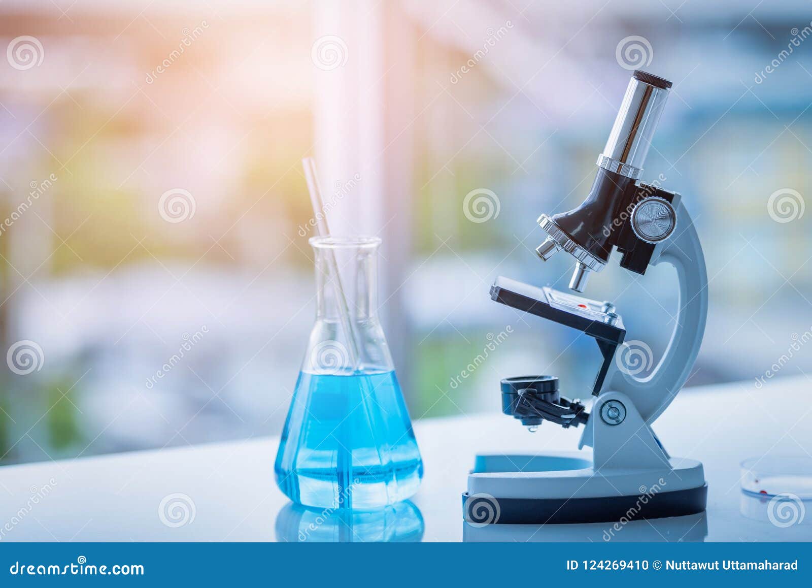 Microscope and Beaker on Table in Laboratory. Science Chemistry Stock