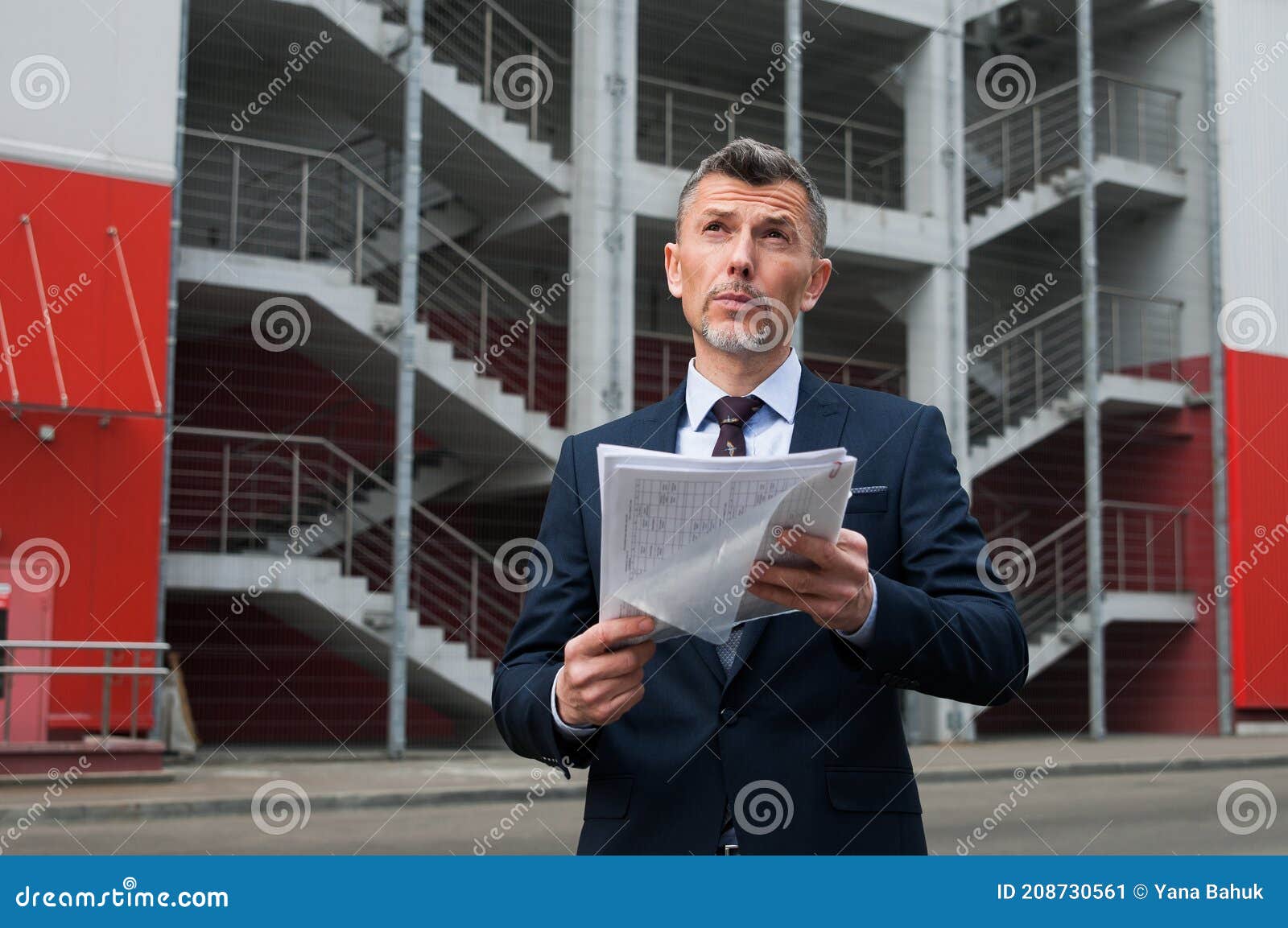 mid adult businessman writing on clipboard in metal industry
