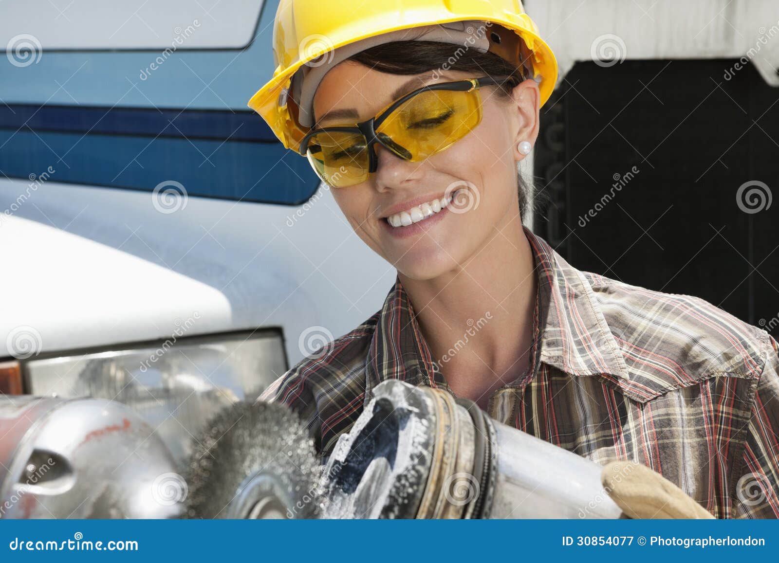 mid adult female industrial worker buffing a truck engine cylinder