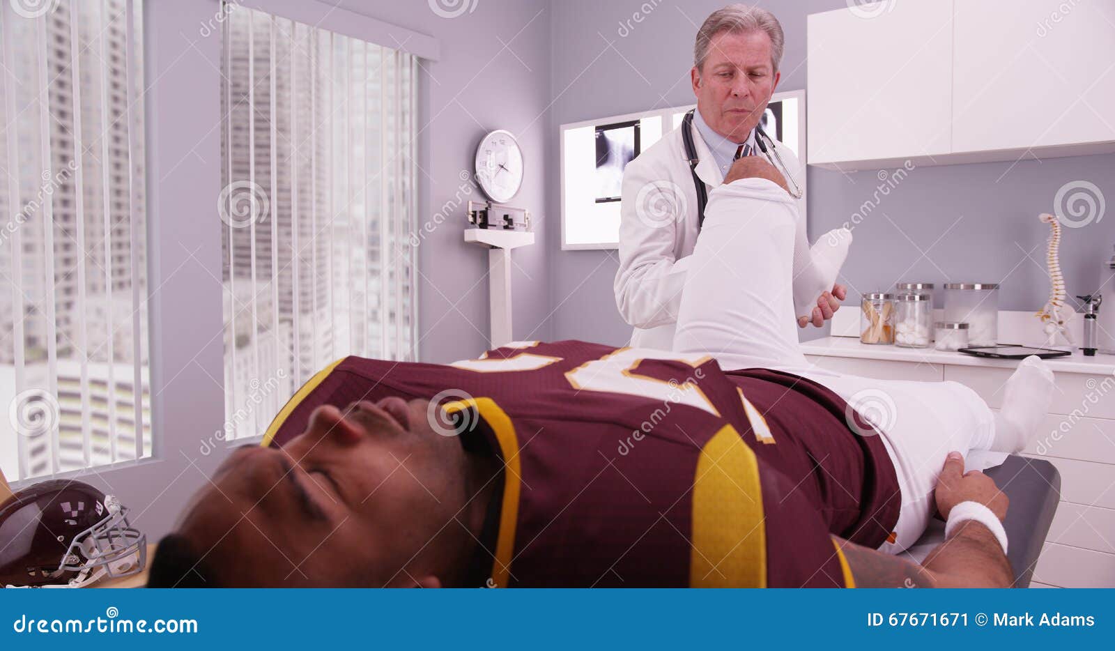 Midaged Physical Therapist Examining College Athlete Sports Injury