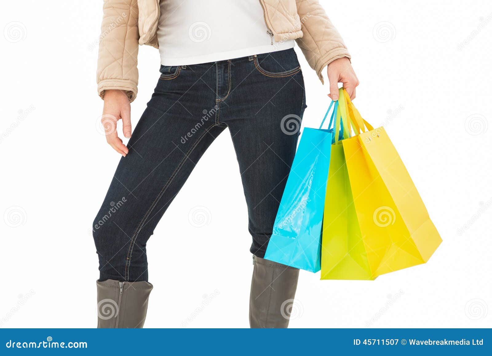 Mid section of woman holding shopping bags on white background