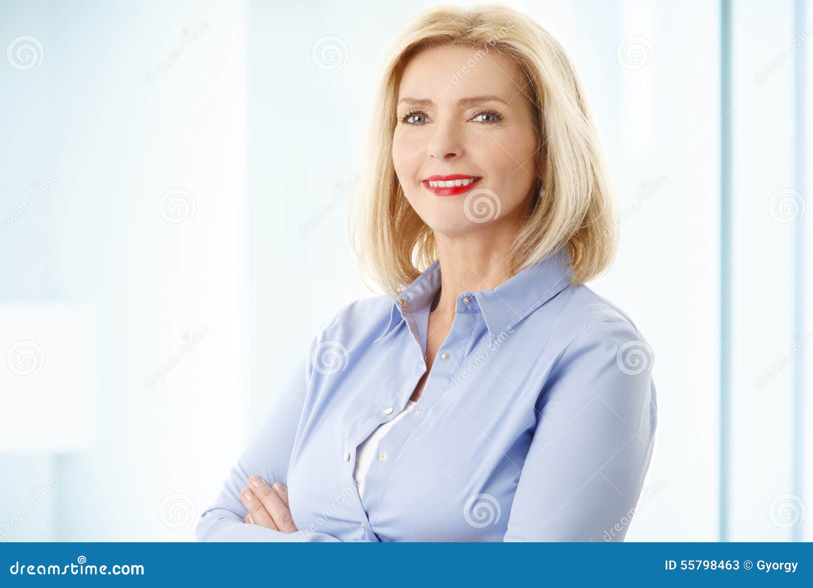 Middle-aged woman with crossed arms, middle age cute woman posing