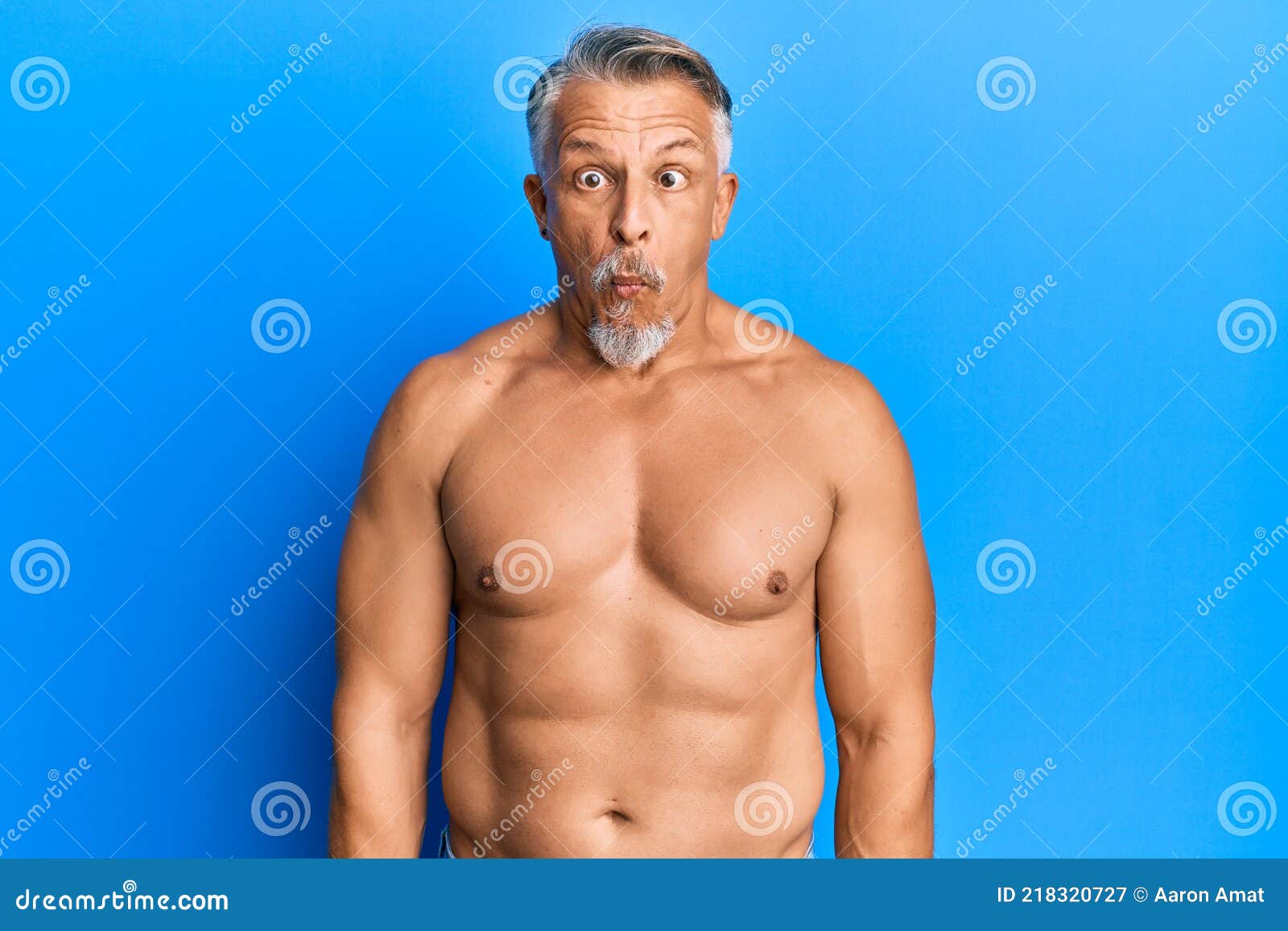 Middle Age Grey-haired Man Standing Shirtless Making Fish Face