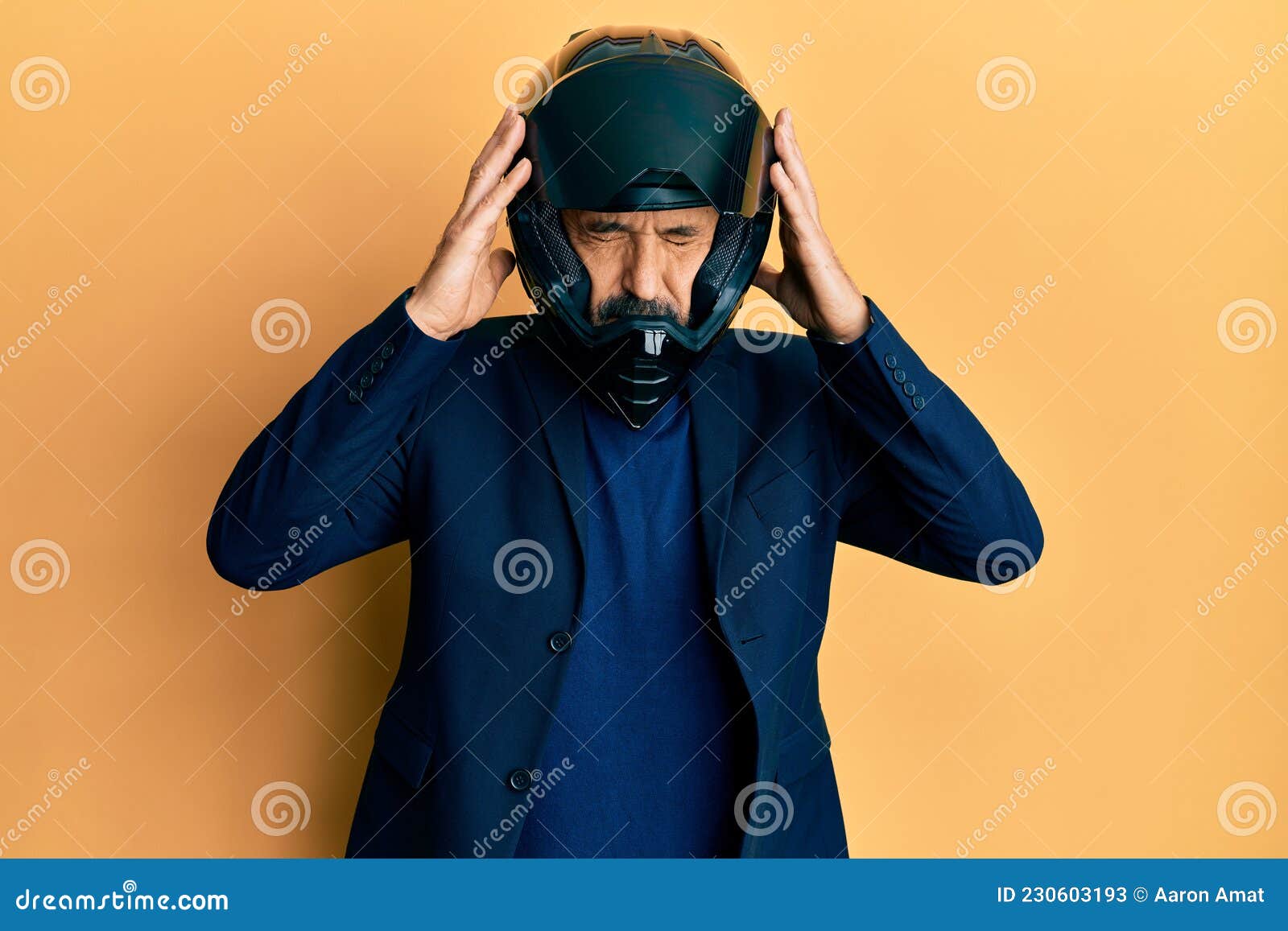 Middle Age Hispanic Man Wearing Motorcycle Helmet with Hand on Head