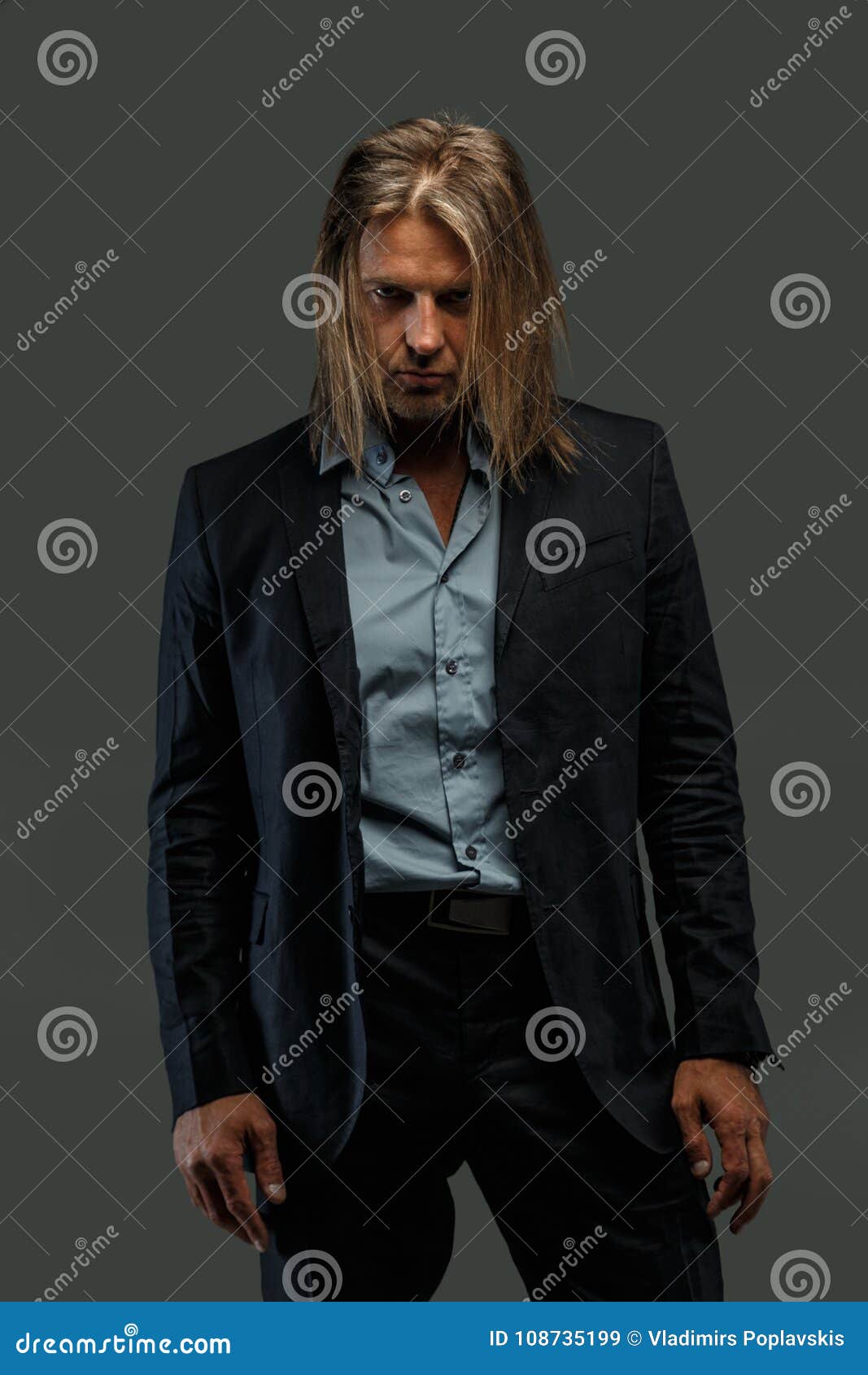 long hair man in suit possing. stock image - image of