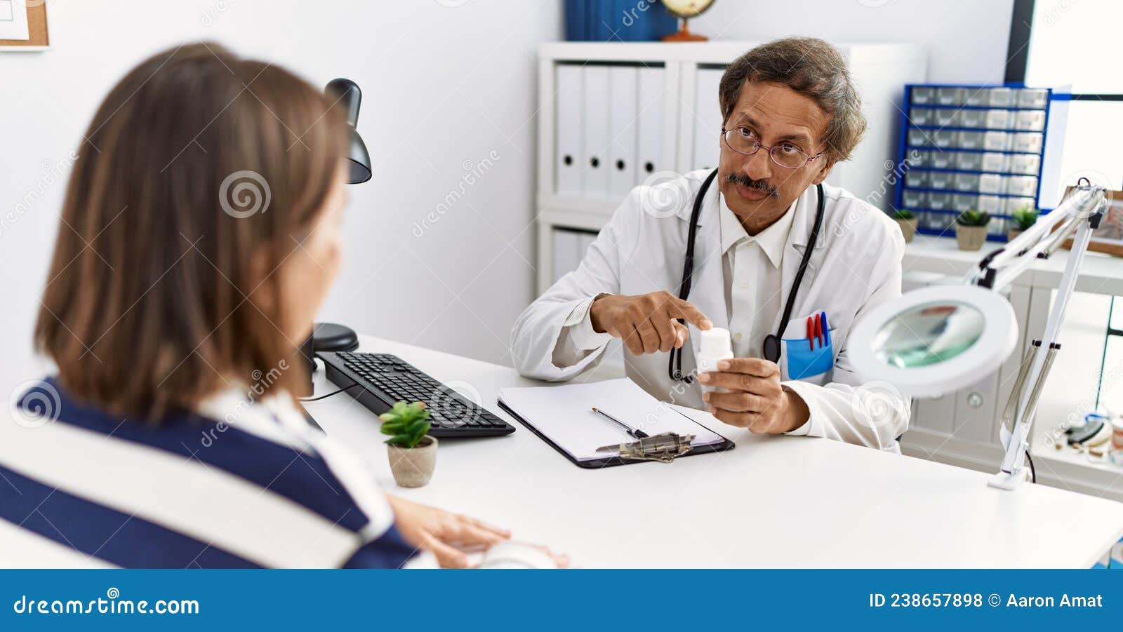 middle age man and woman wearing doctor uniform having medical consultation holding pills at clinic