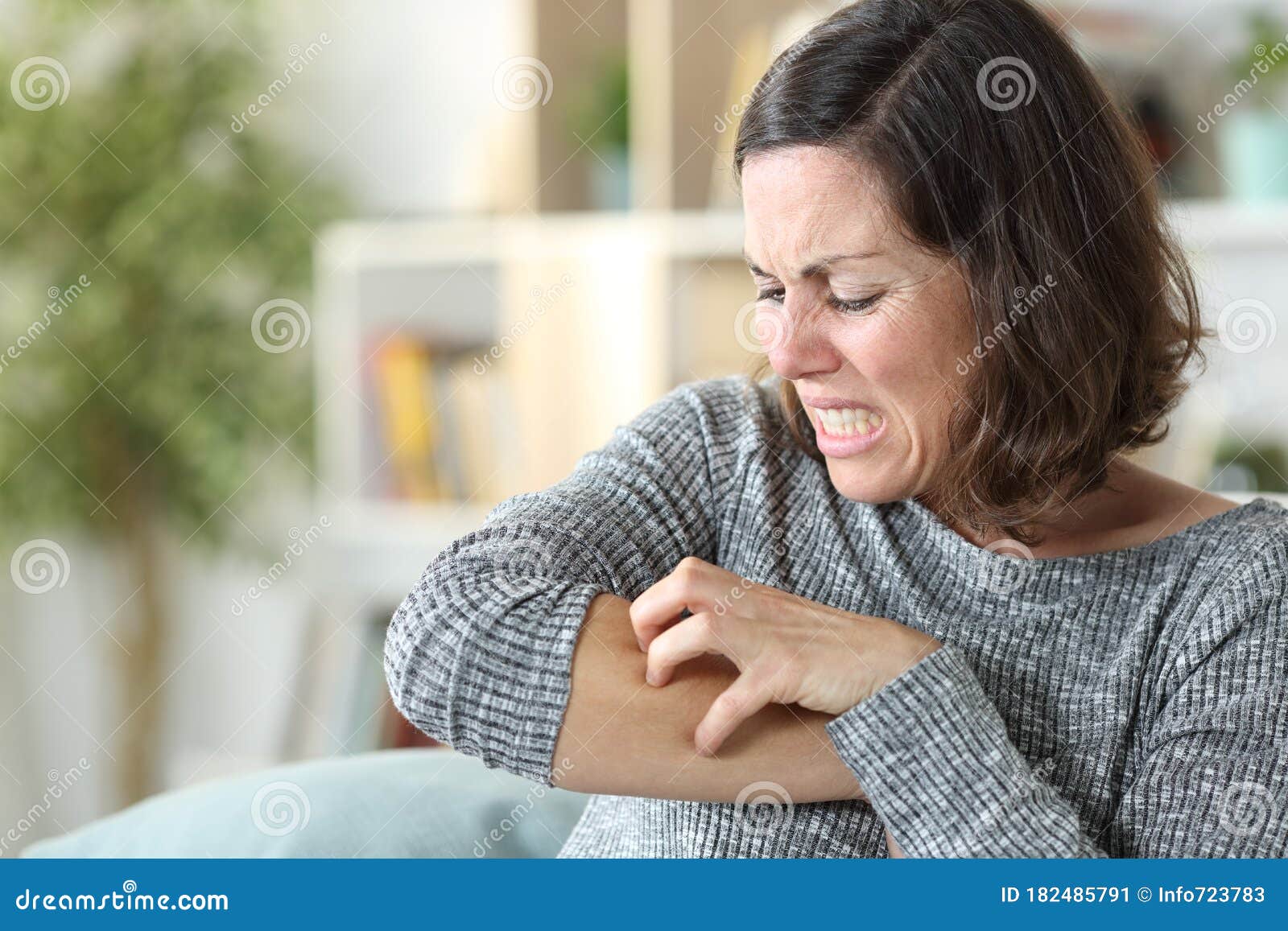 middle age woman scratching itchy skin at home