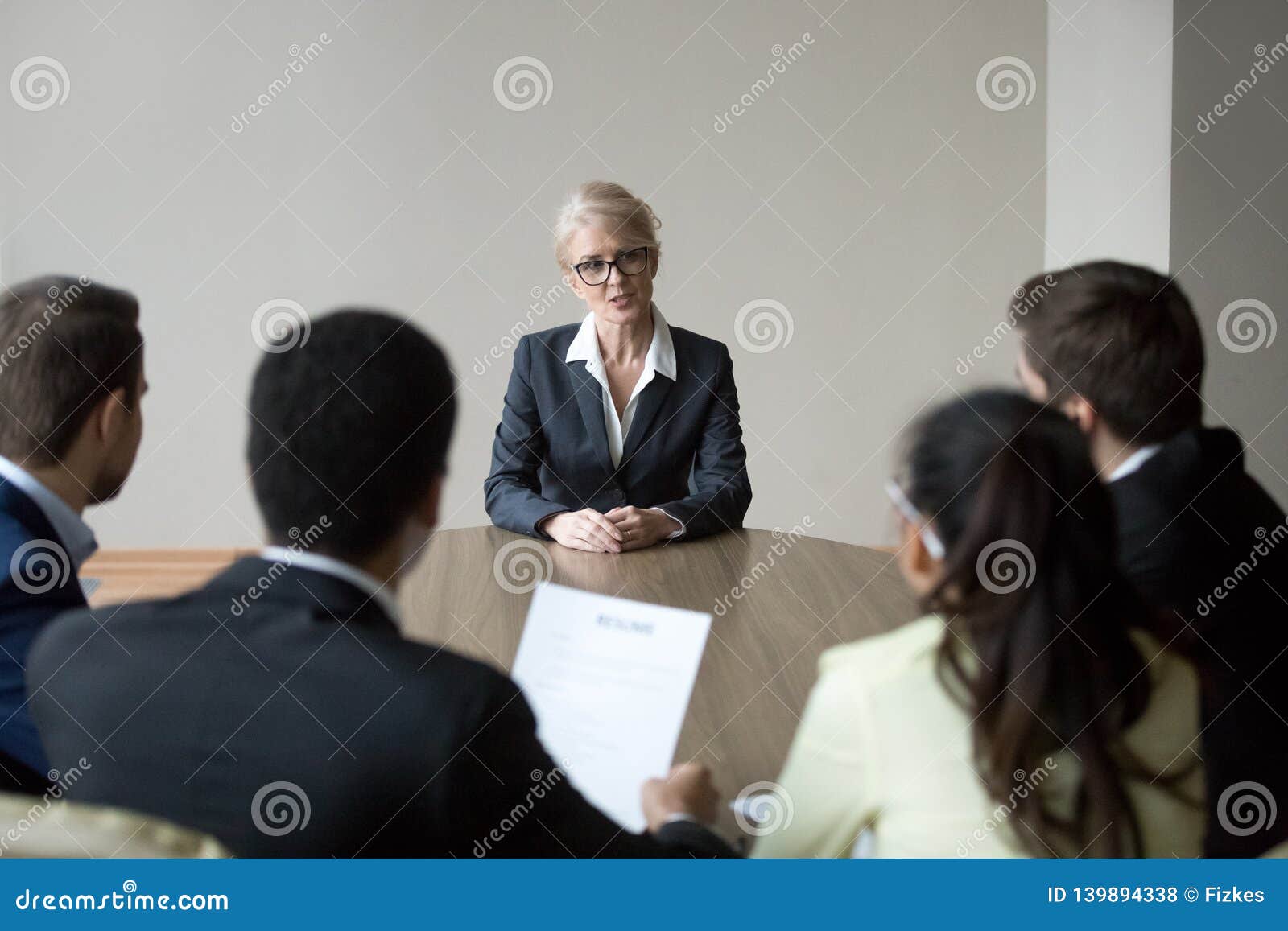 middle-aged confident applicant talking to hr managers during job interview
