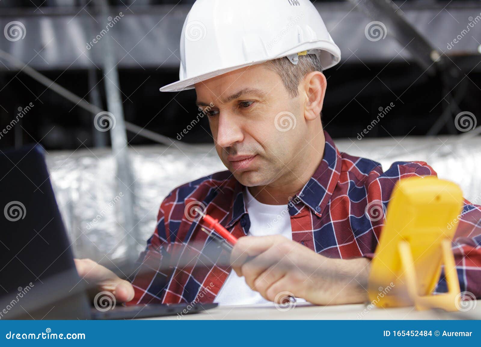 Middle Aged Electrician Using Laptop and Multimeter Stock Photo Image