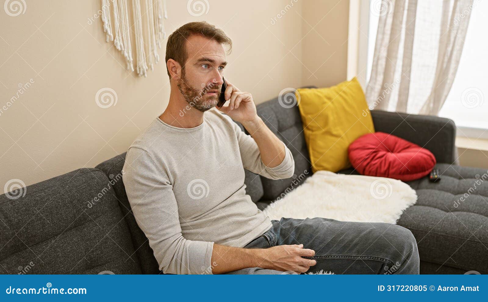 a middle-aged hispanic man with a beard talks on the phone in a cozy living room setup, adding a personal touch to the indoor