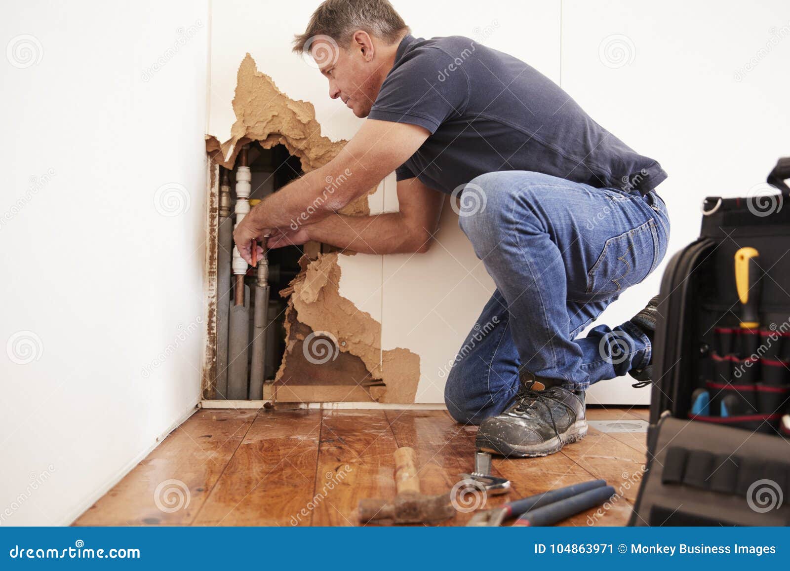 Middle Aged Man Repairing Burst Water Pipe Stock Image Image of kneeling, horizontal 104863971