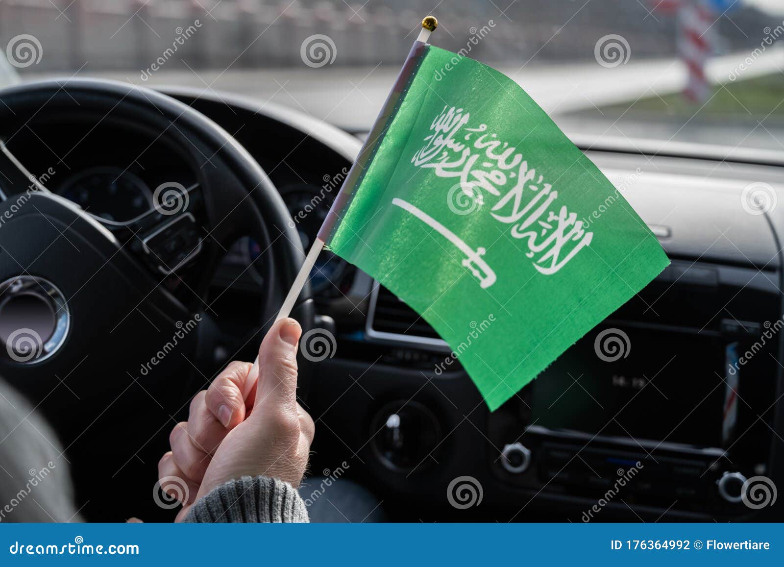 Middle Aged Man with Saudi Arabia Flag Driving a Car. Stock Photo