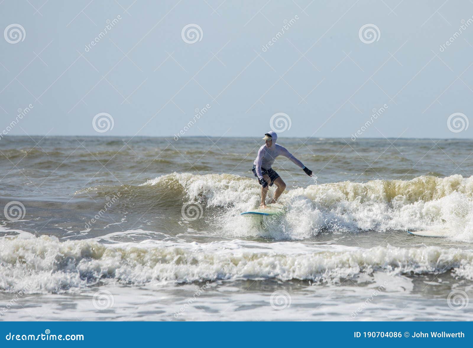 middle aged man surfs on a longboard in the atlantic