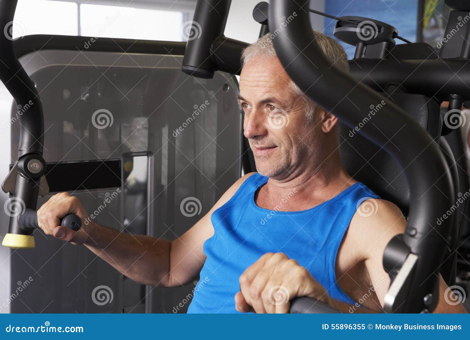 Middle Aged Man Using Weights Machine in Gym Stock Image - Image of ...