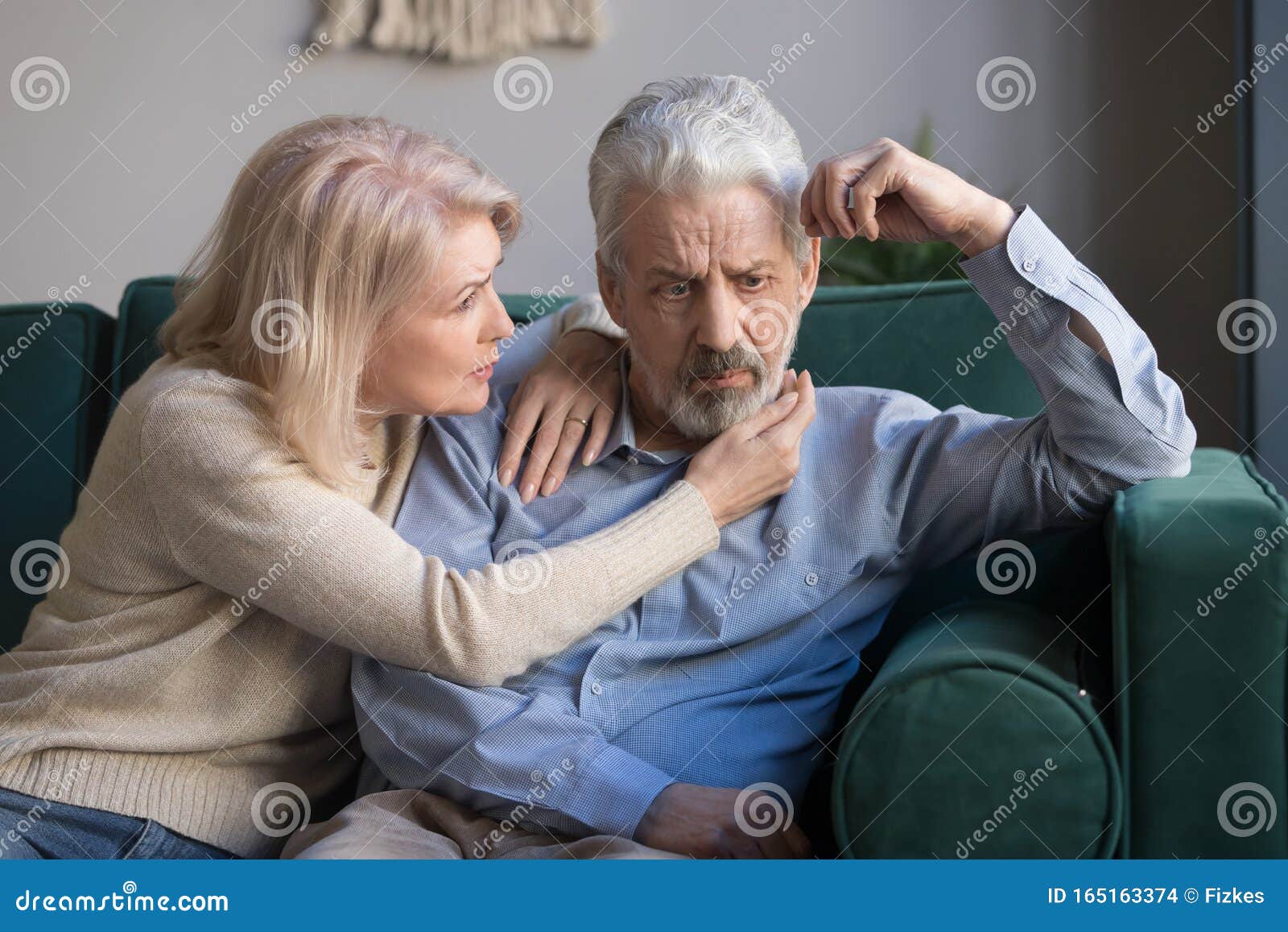 middle aged wife comforting upset grey-haired husband