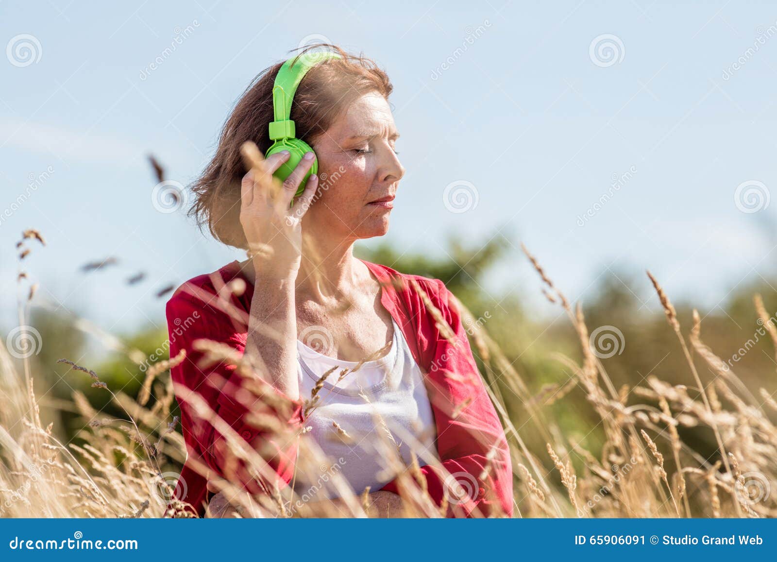 middle aged woman enjoying quietness with music outdoors
