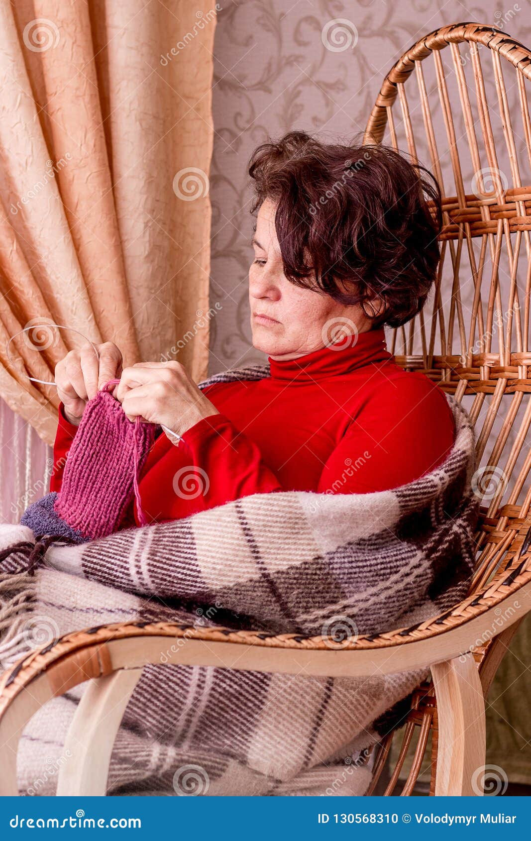 A Middle-aged Woman Sits in a Rocking Chair. Woman Knitting a so Stock ...