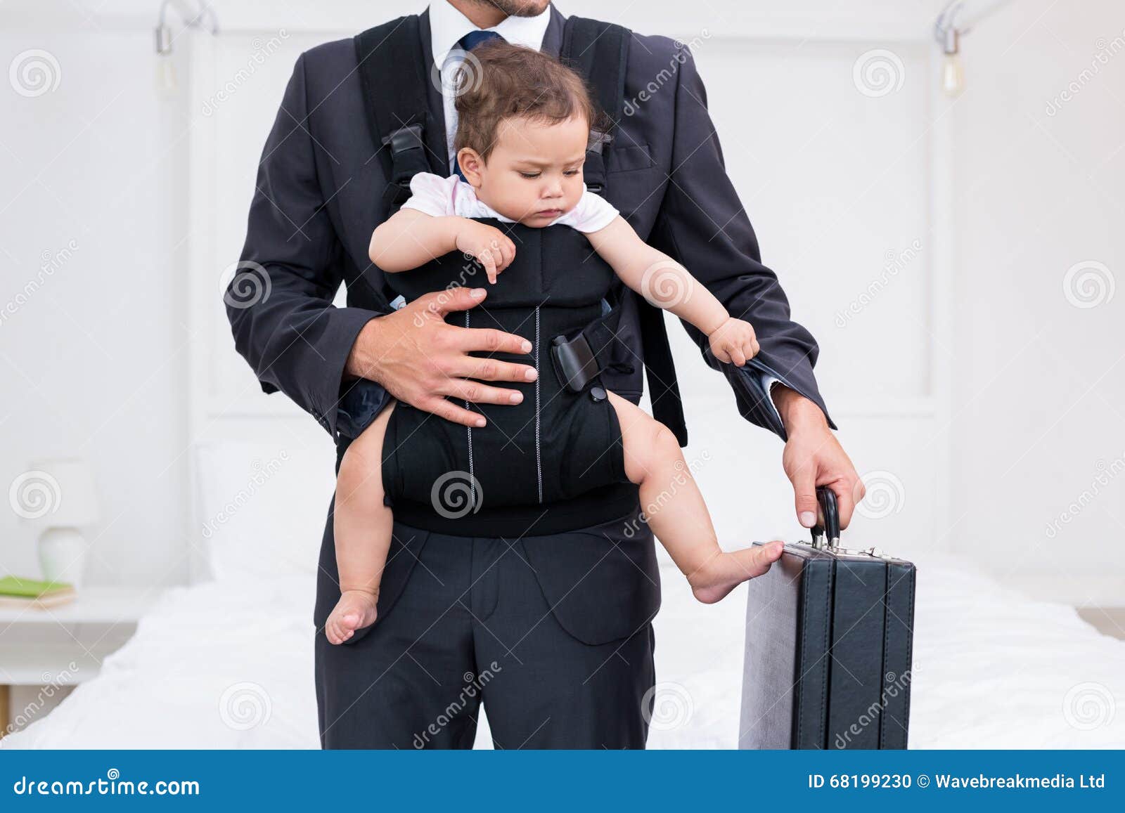 midsection of father carrying baby while holding briefcase