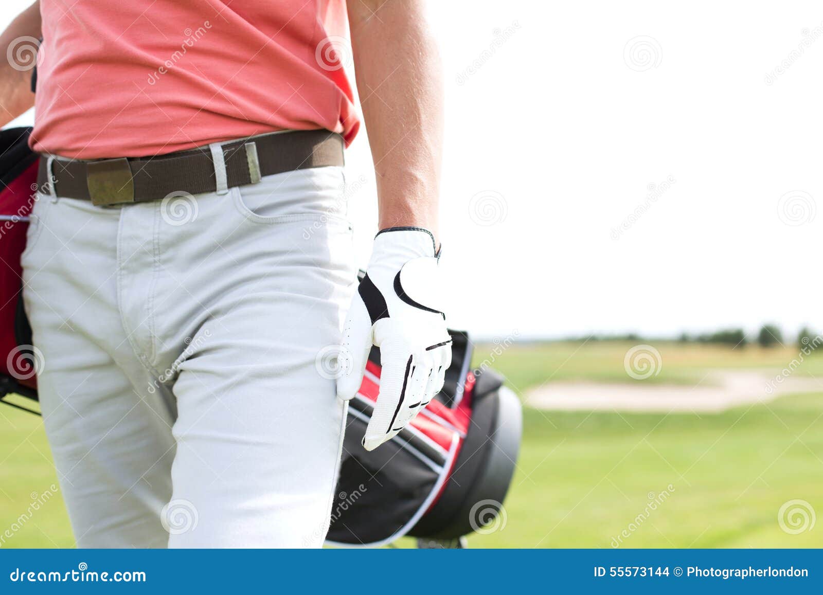 Midsection of Man Carrying Golf Club Bag while Walking at Course Stock